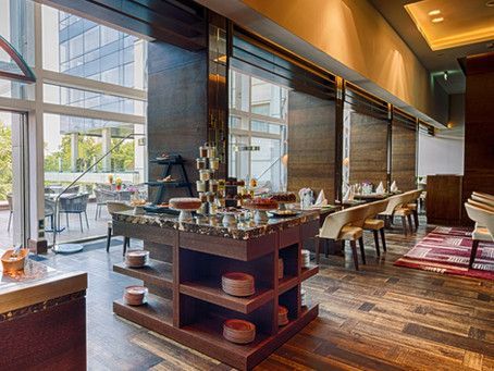 A restaurant with a lot of shelves and tables and chairs.
