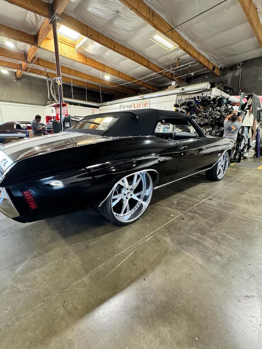 A black car is parked in a garage.