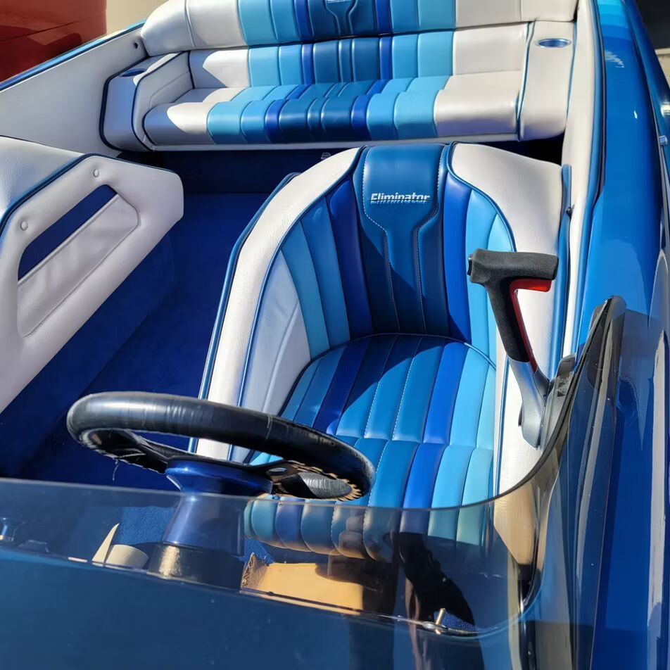 A blue and white boat with a steering wheel