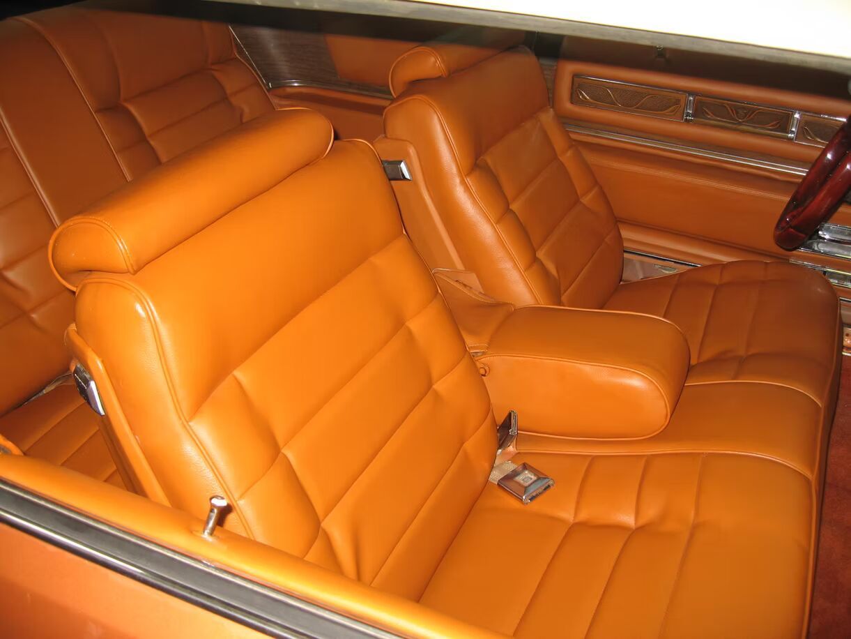 The inside of a car with orange leather seats