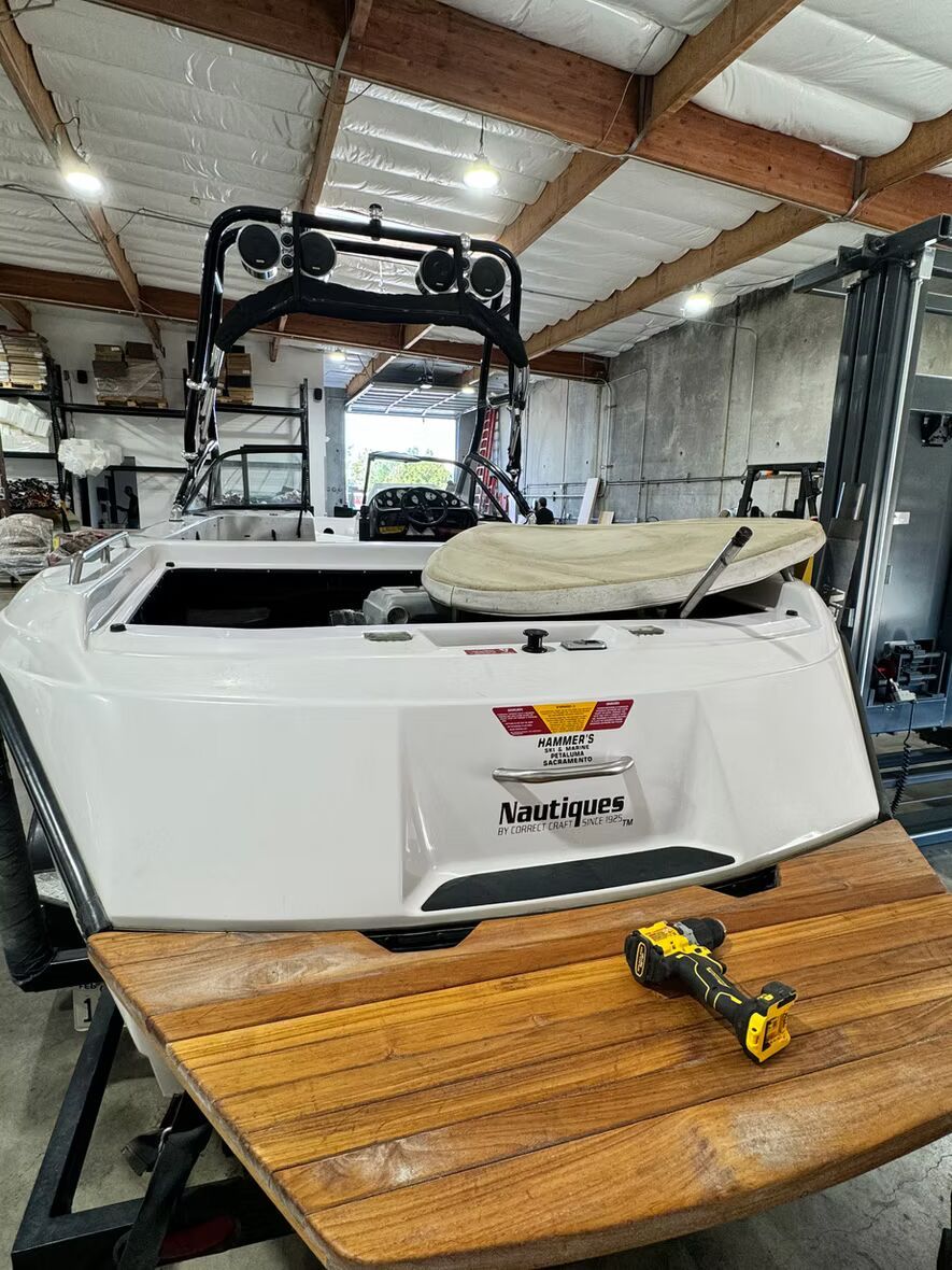 A boat is sitting on top of a wooden table in a garage.