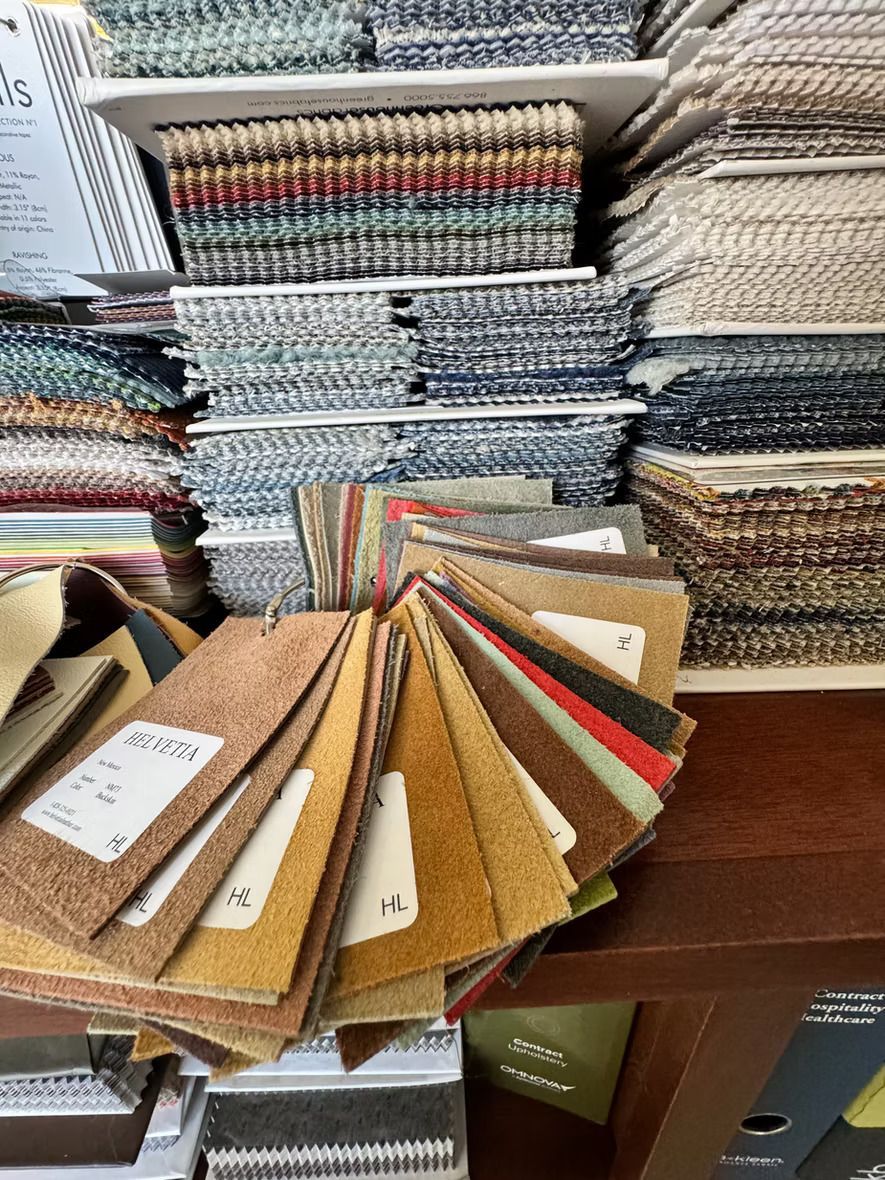 A bunch of fabric samples are stacked on top of each other on a table.