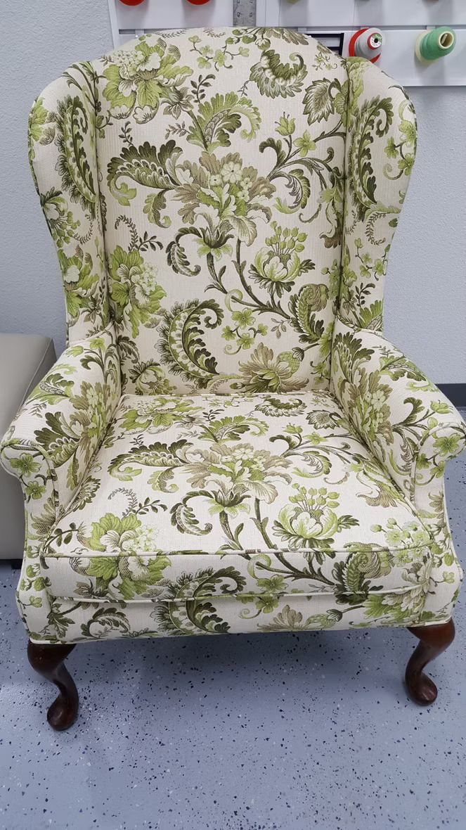A green and white chair with a floral pattern on it