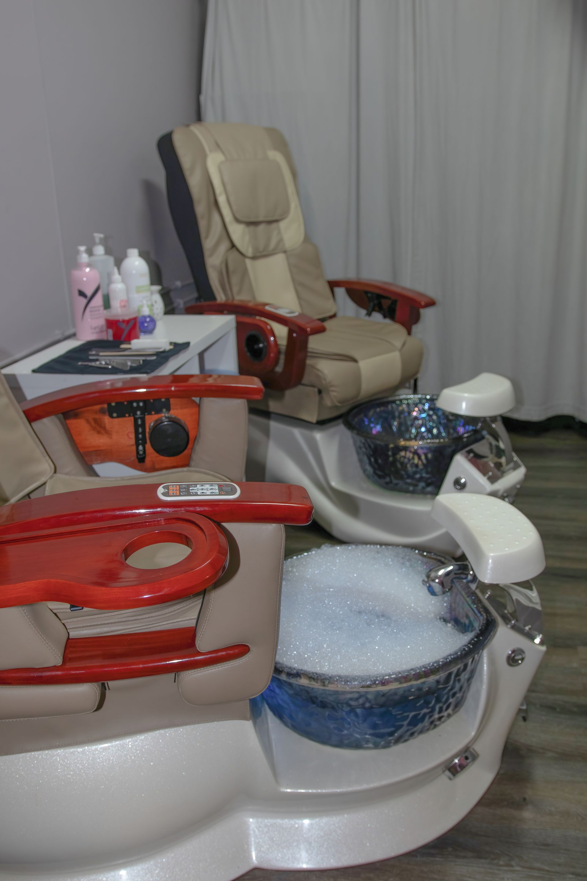 Two pedicure chairs with foot baths in a spa setting. One has bubbles. — Admire Skincare and Beauty in Taree, NSW