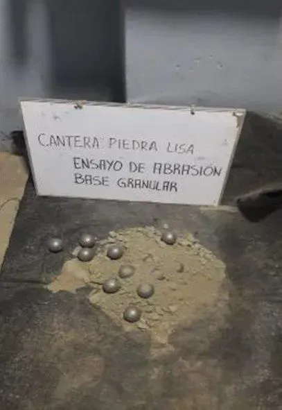 Stones beside a sign reading “Cantera Piedra Lisa, ensayo de abrasión base granular”