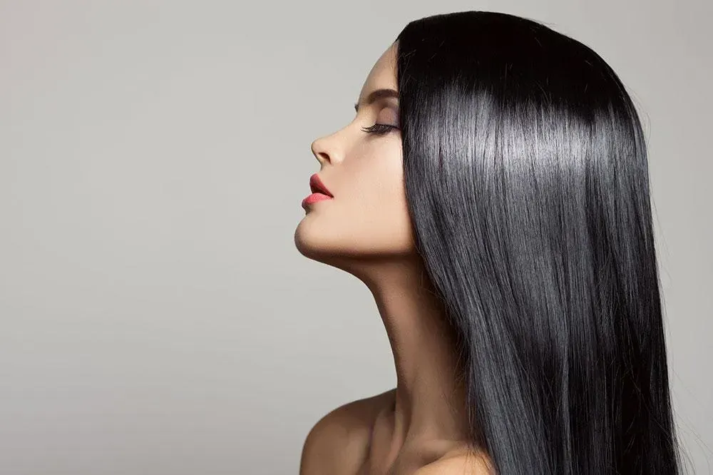 Una mujer con cabello largo y negro está mirando al cielo.