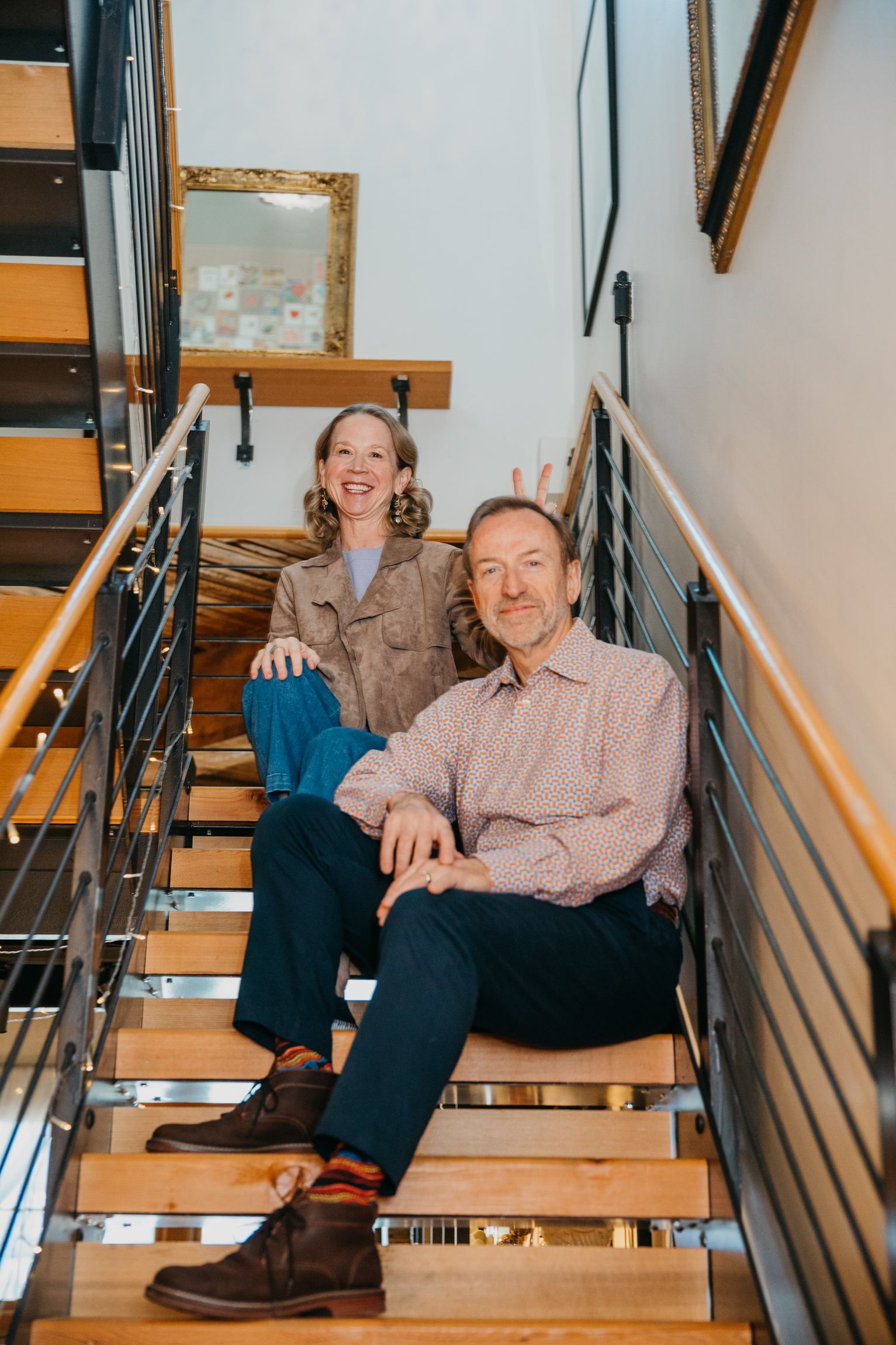 April and Jerry sitting together on wooden stairs with metal railing