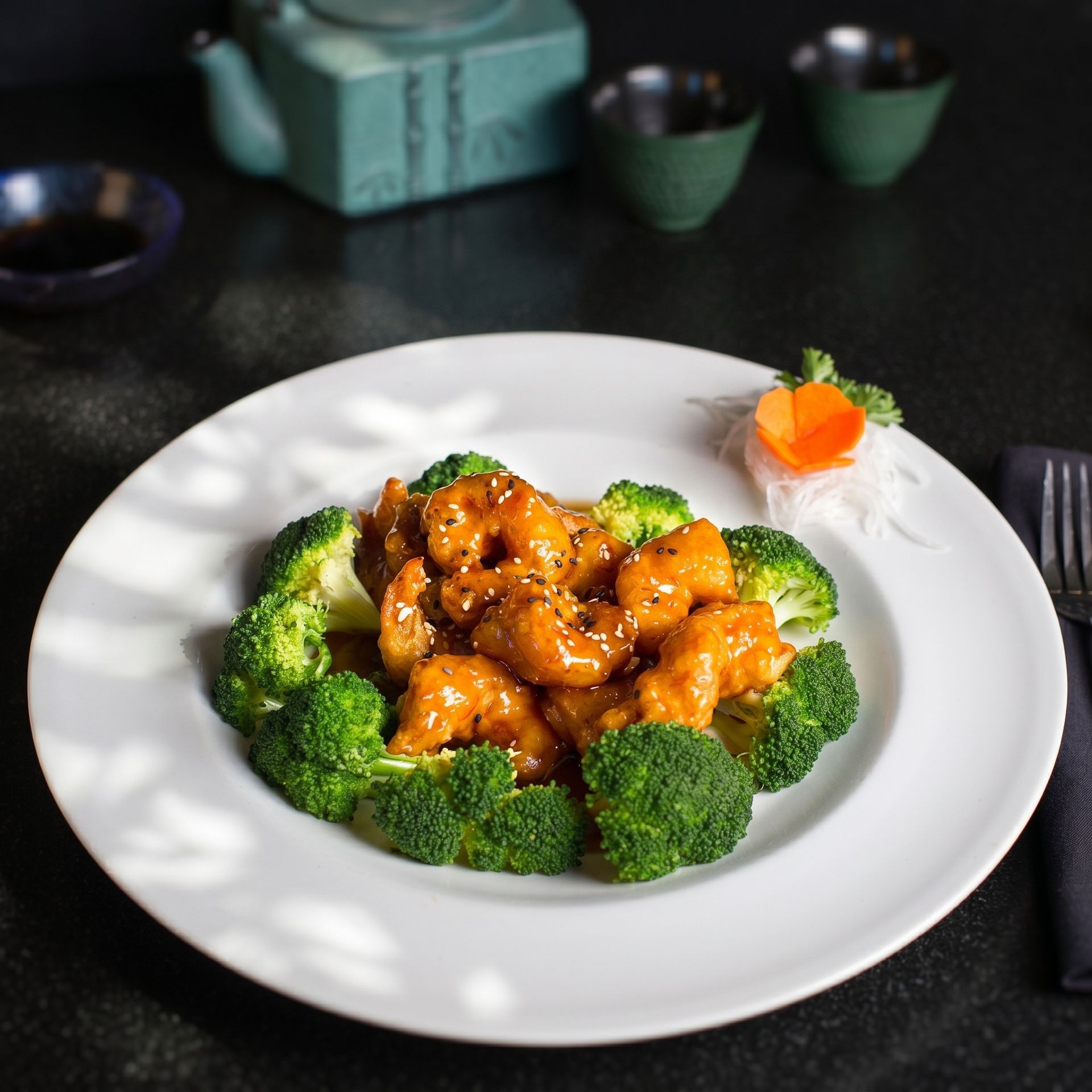 Broccoli ring around glazed chicken on a white plate with a carrot garnish