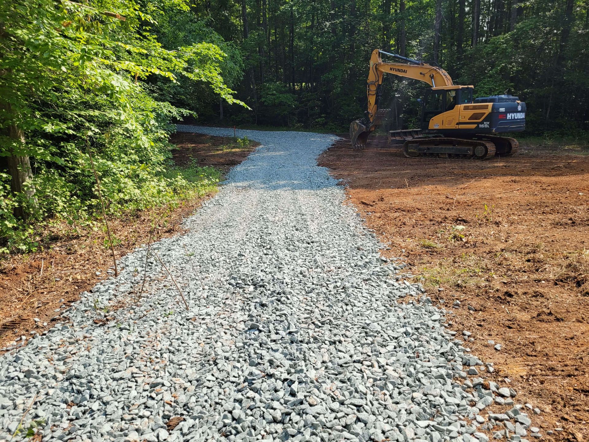 Excavator clearing overgrown land during site preparation near Richmond, VA