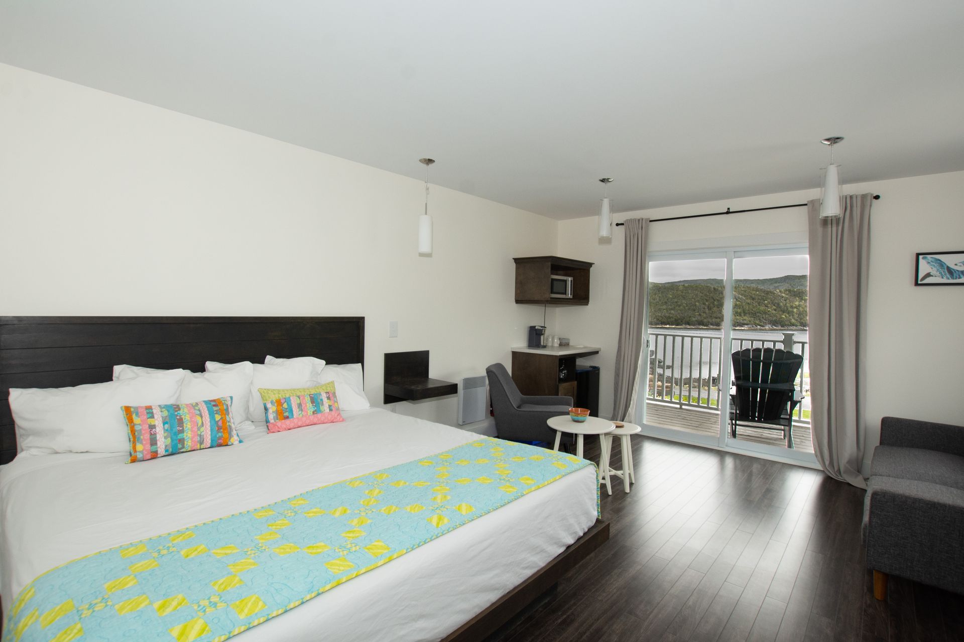 A hotel room with a king size bed and a balcony.