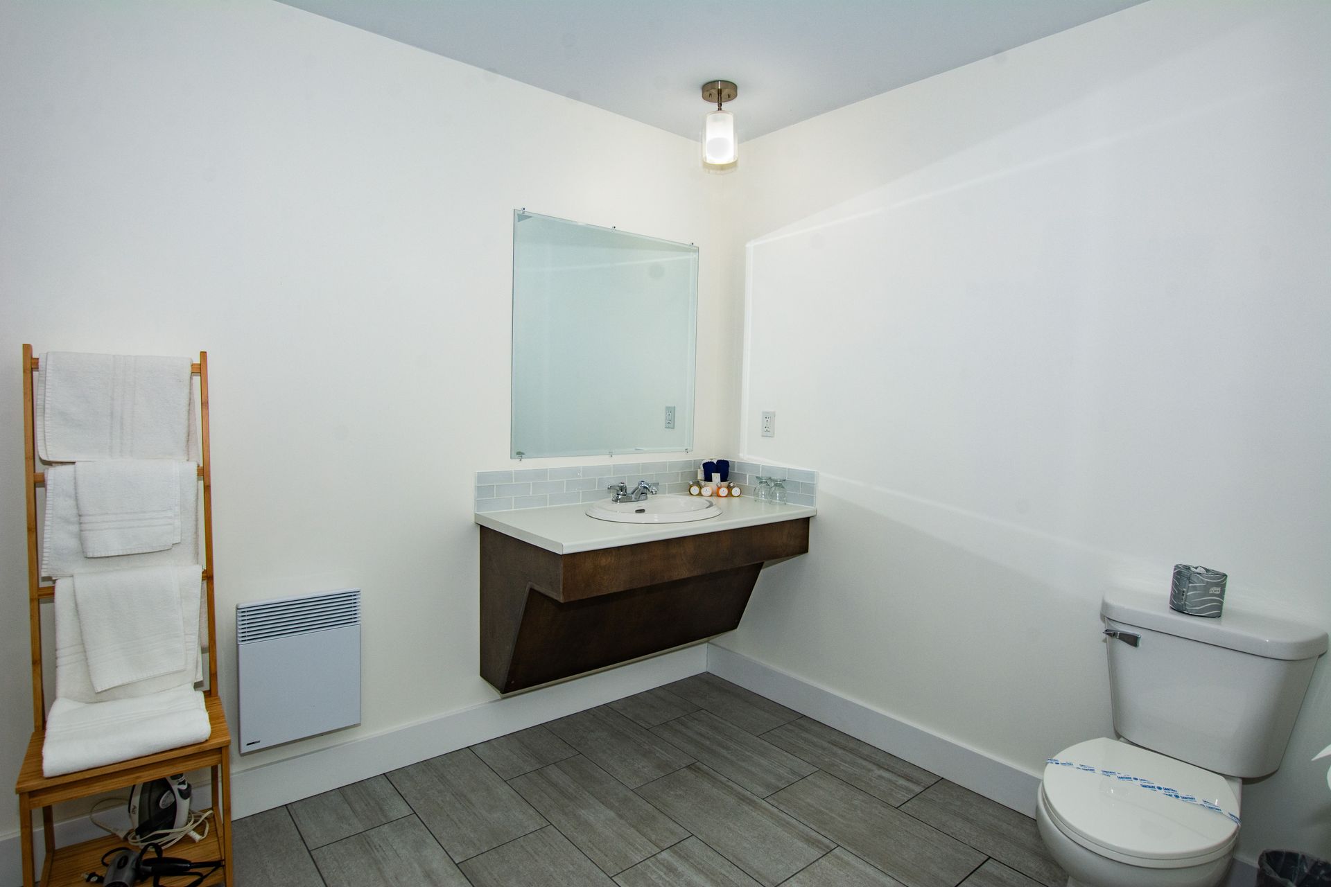 A bathroom with a sink , toilet and mirror.