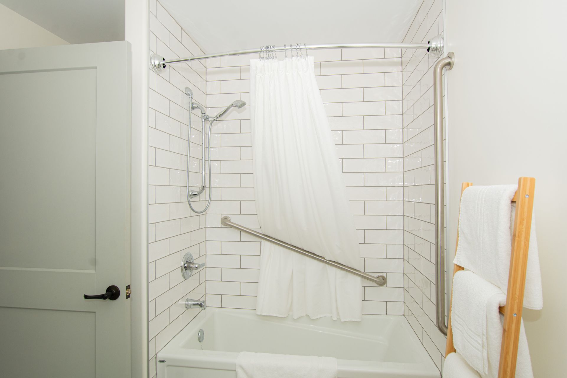 A bathroom with a bathtub , shower , and towel rack.