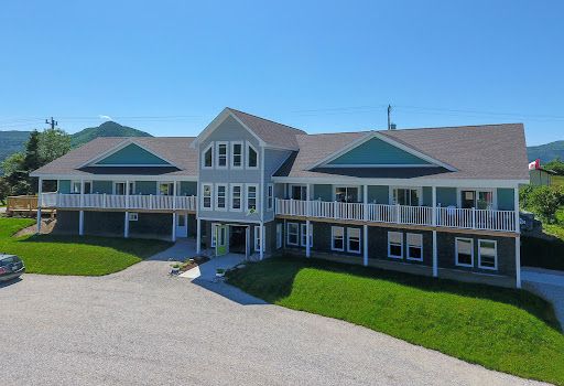A large house with a lot of windows and a car parked in front of it.