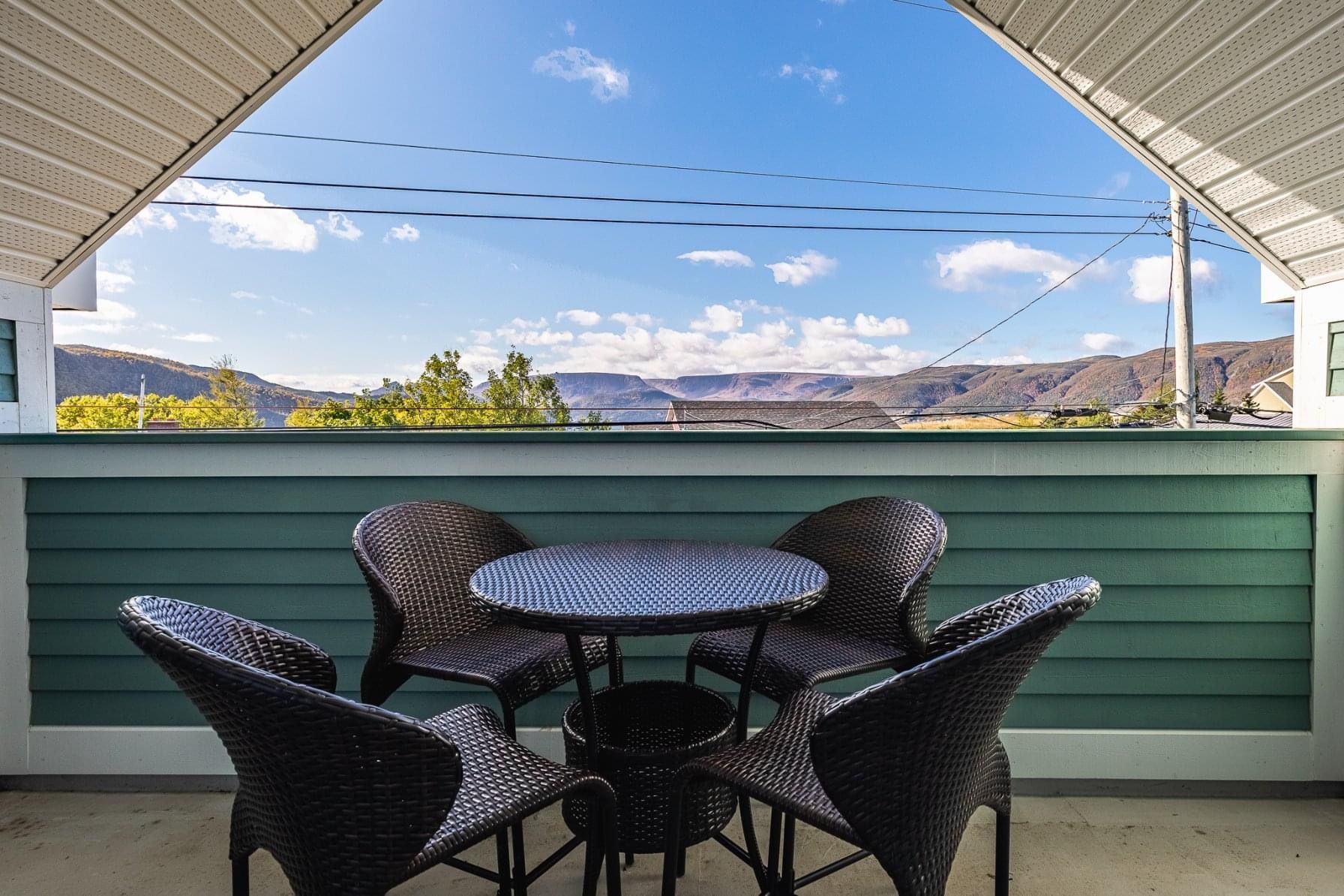 A balcony with a table and chairs and a view of the mountains.