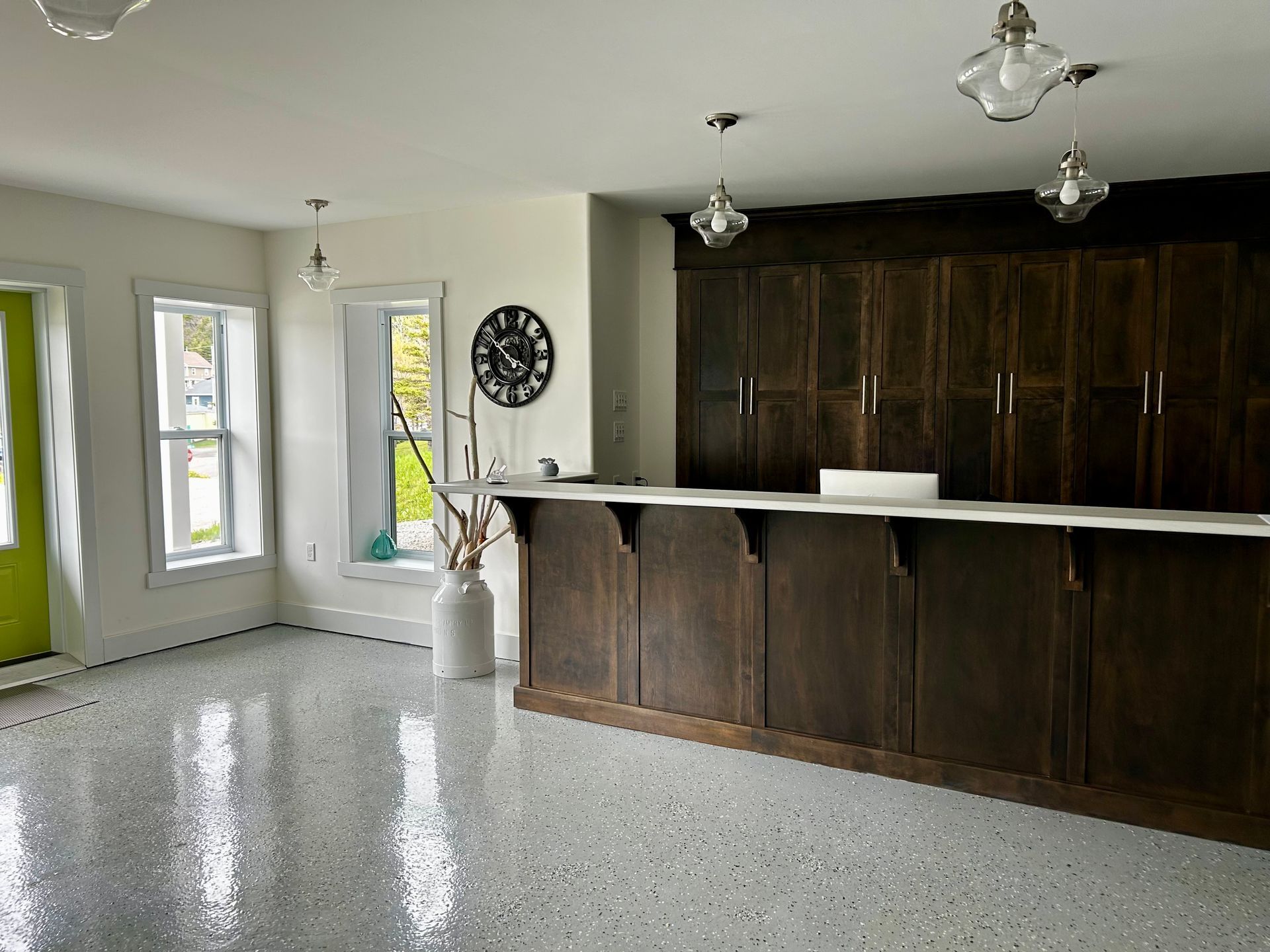 There is a clock on the wall above the counter in the room.