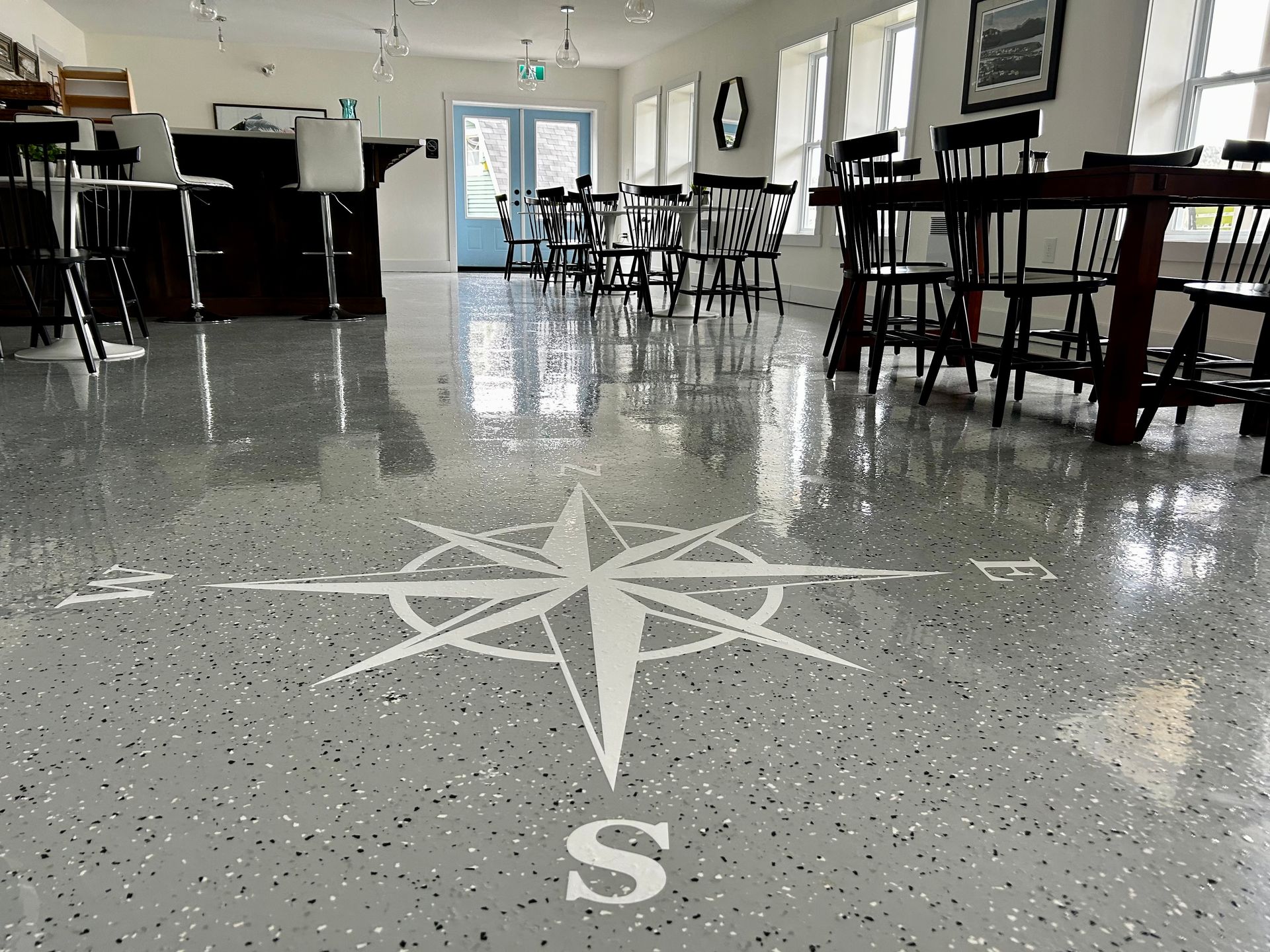 A large room with tables and chairs and a compass on the floor