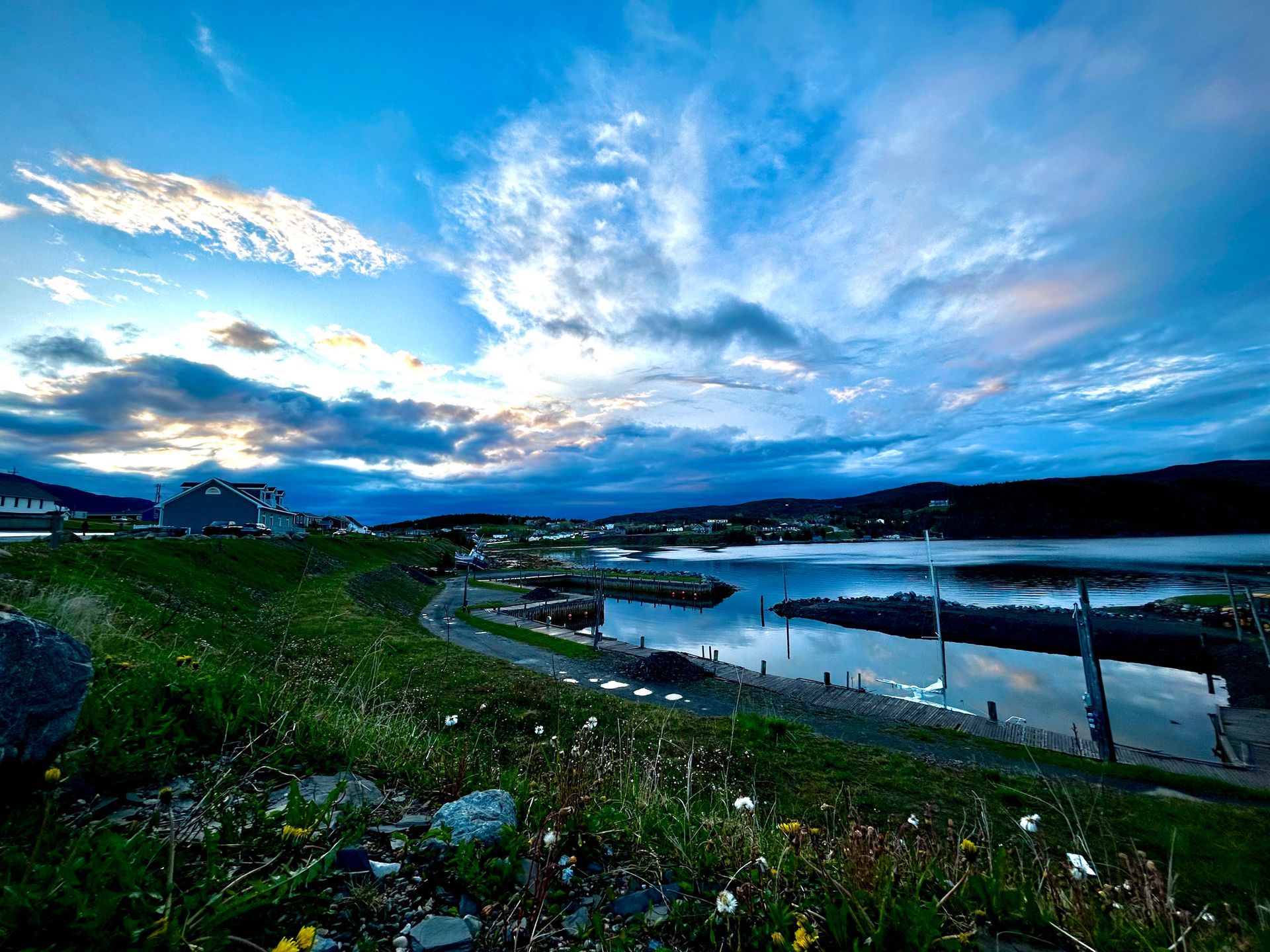 A view of a lake at sunset with a blue sky and clouds.