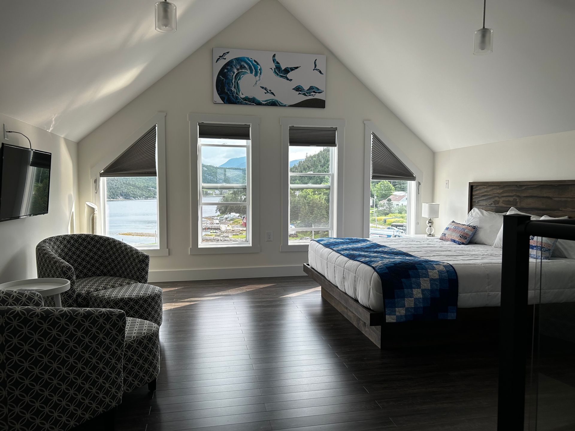 A bedroom with a king size bed and two chairs