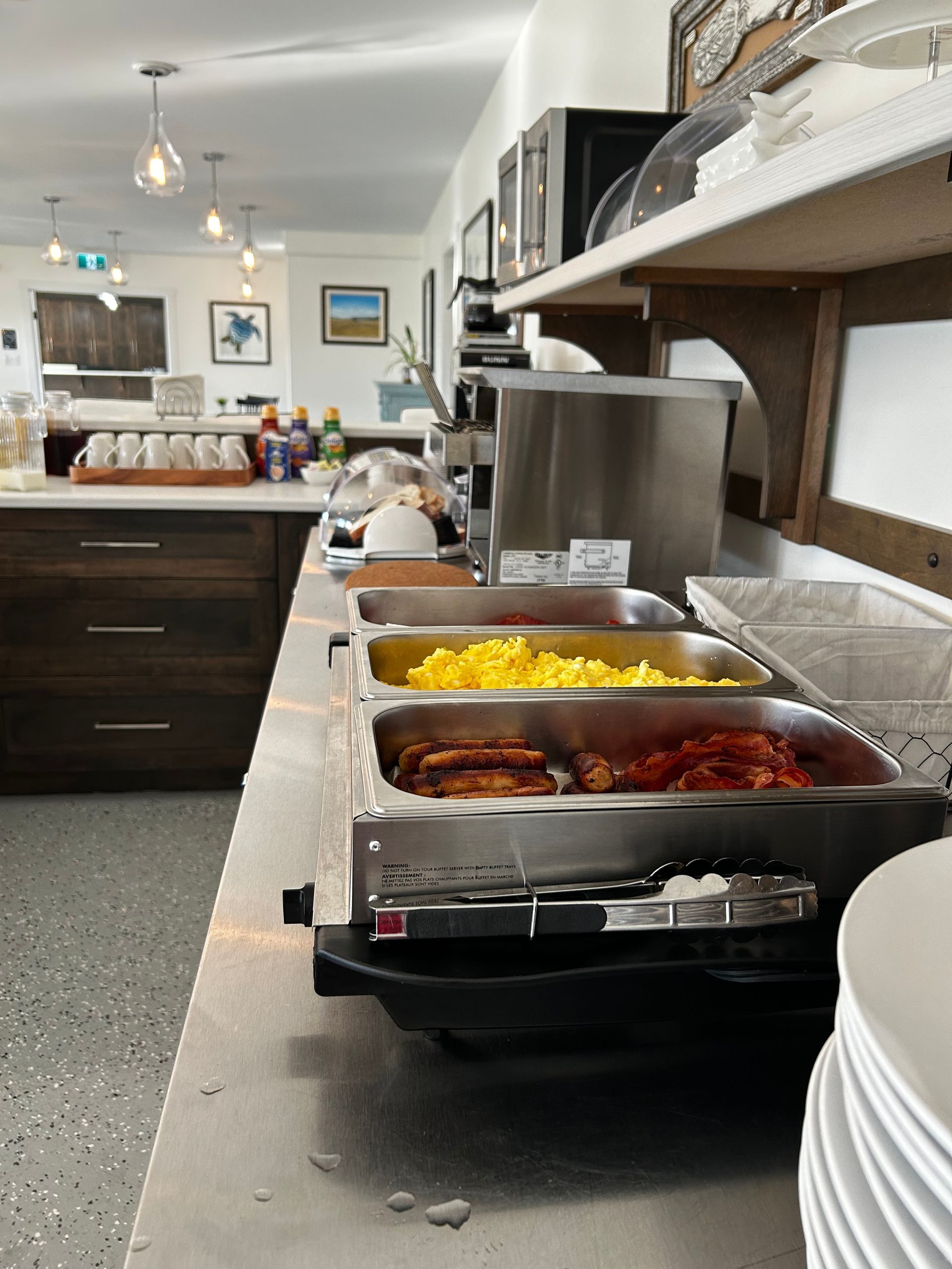 Several trays of food are lined up on a counter in a restaurant
