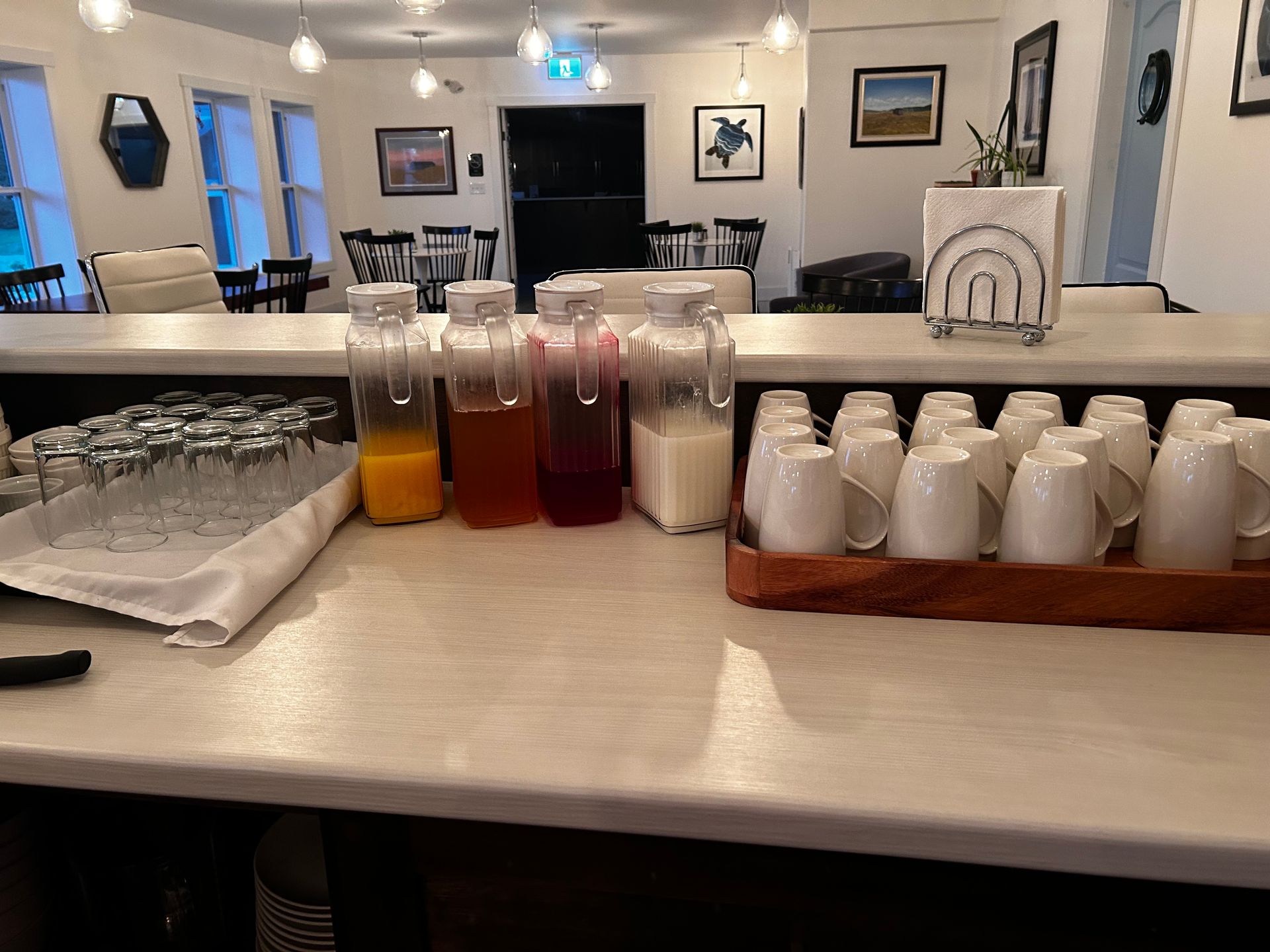 A counter with bottles of drinks and cups on it in a restaurant.
