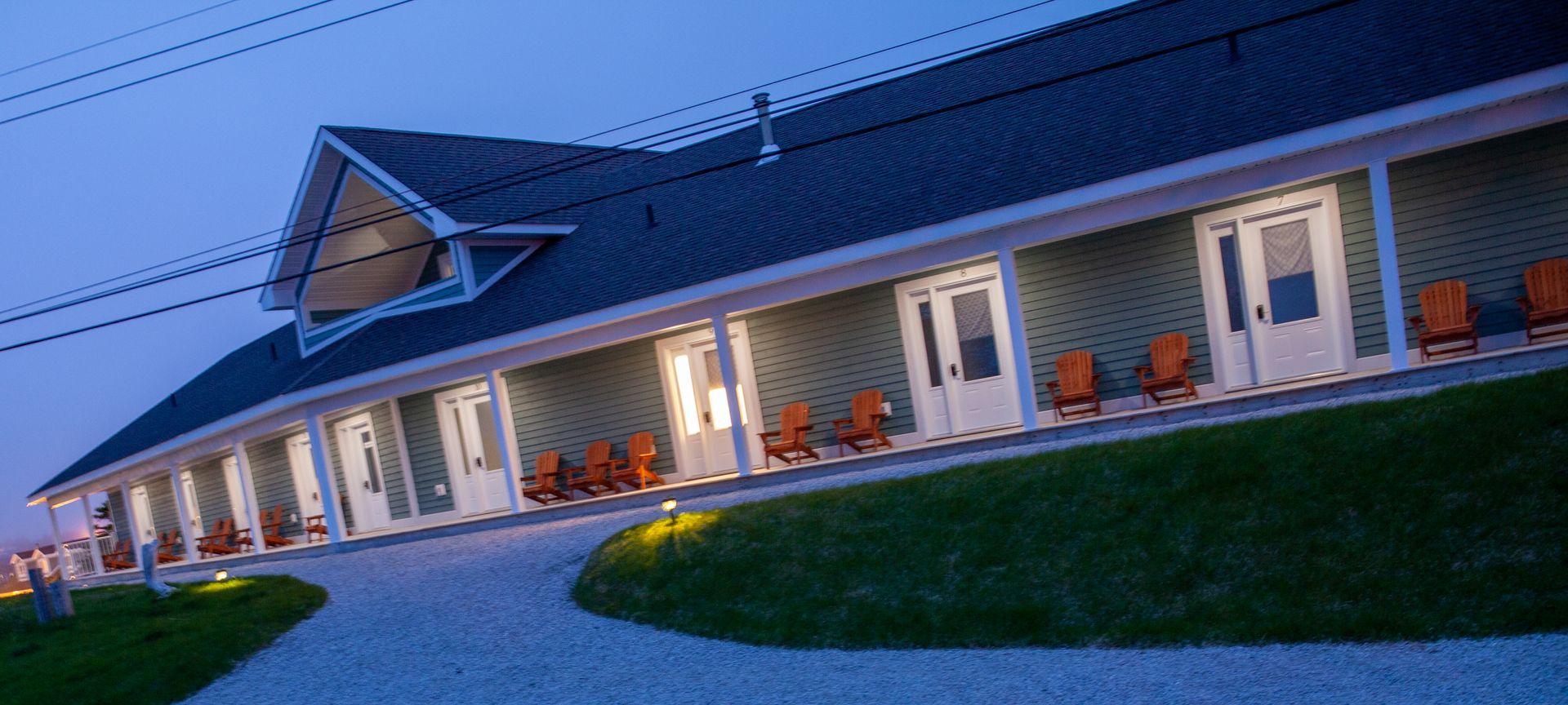 A large house with a lot of windows and chairs on the porch.