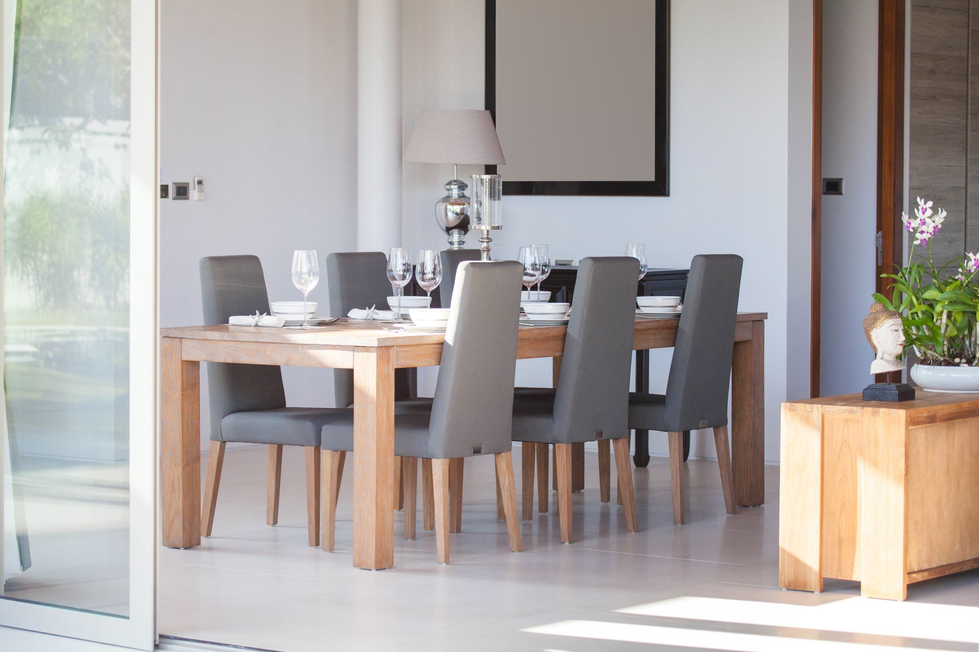 Una sala da pranzo con tavolo, sedie e una porta scorrevole in vetro.