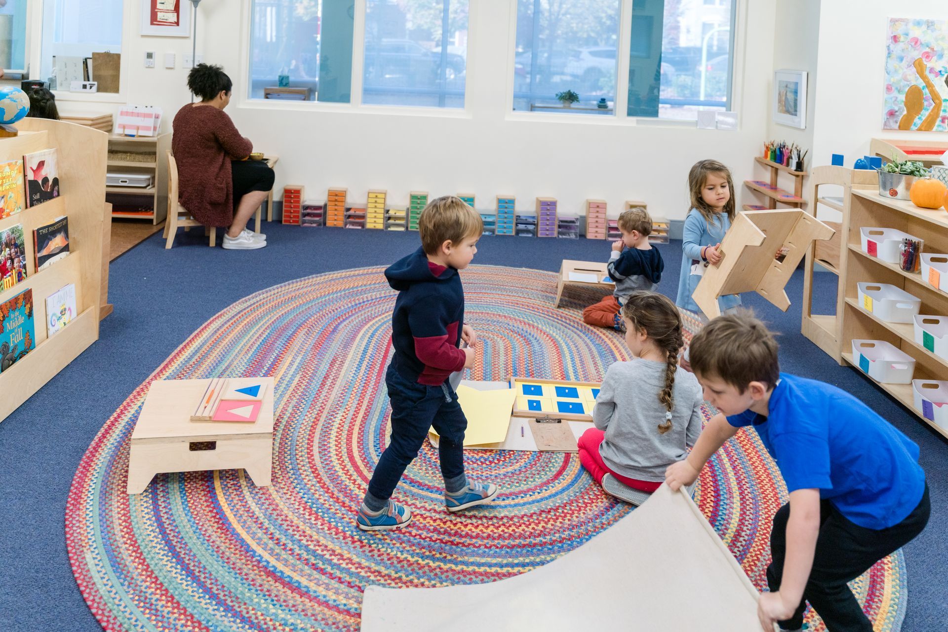 A group of montessori children are working in a classroom.