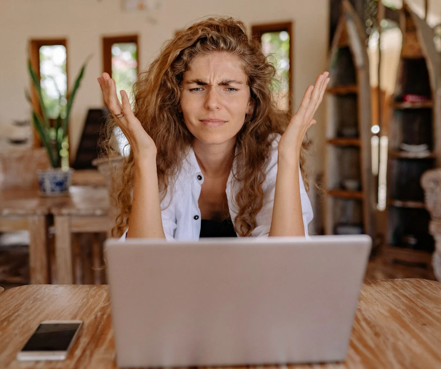 A woman is sitting at a table using a laptop computer.