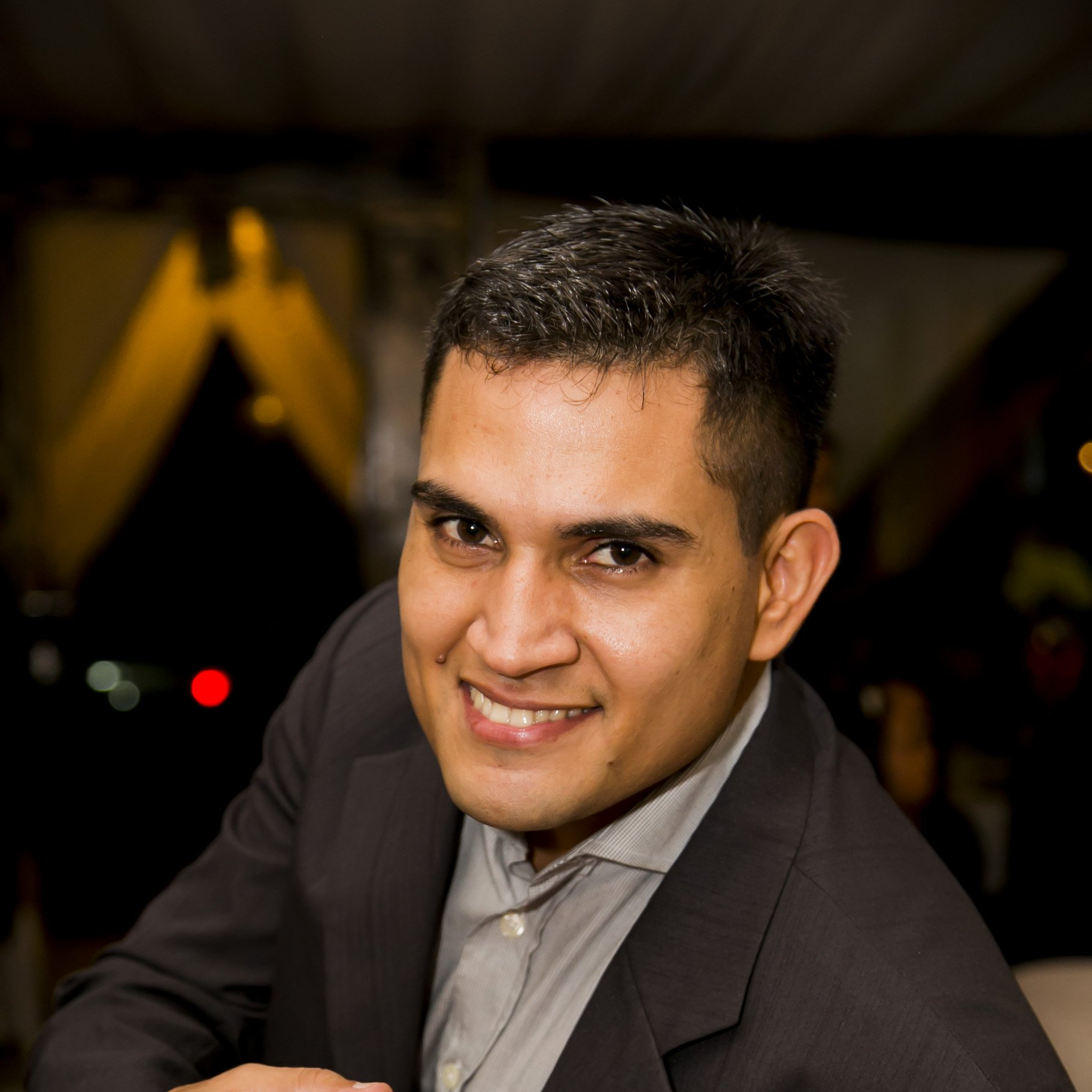 A man in a suit is smiling for the camera