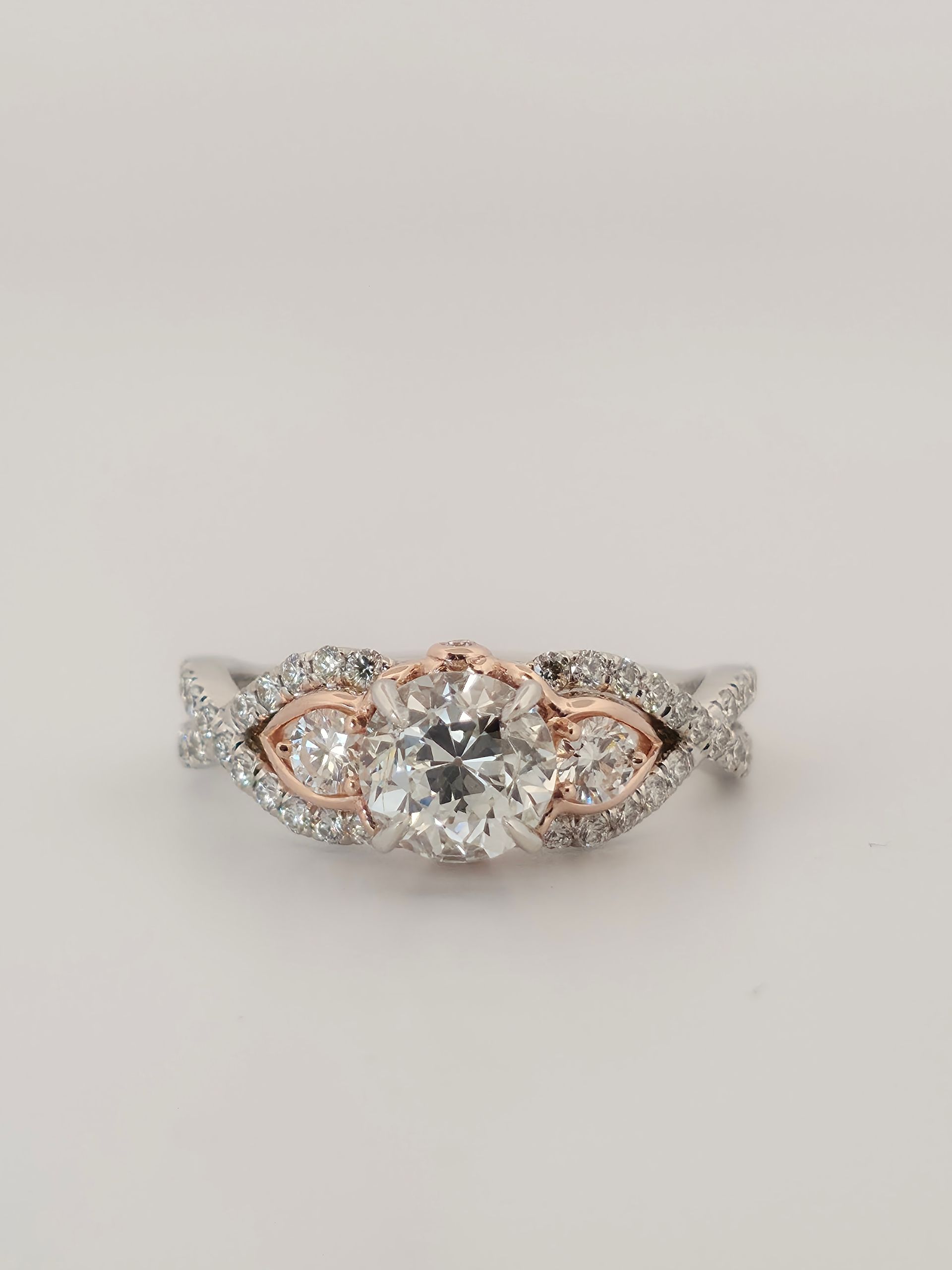 Rose gold and silver floral diamond ring on a white background