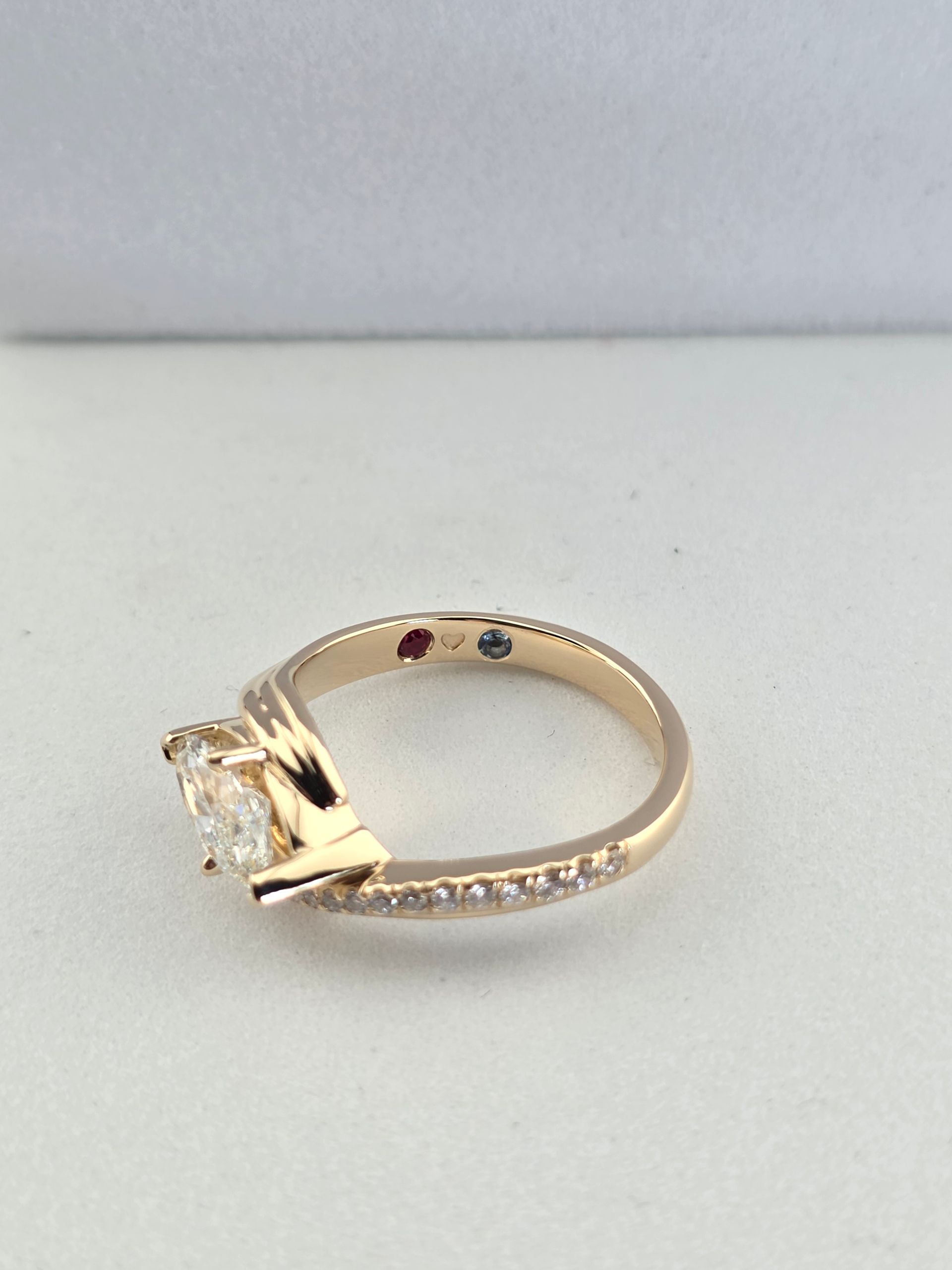 Gold ring with a clear gemstone on a white surface