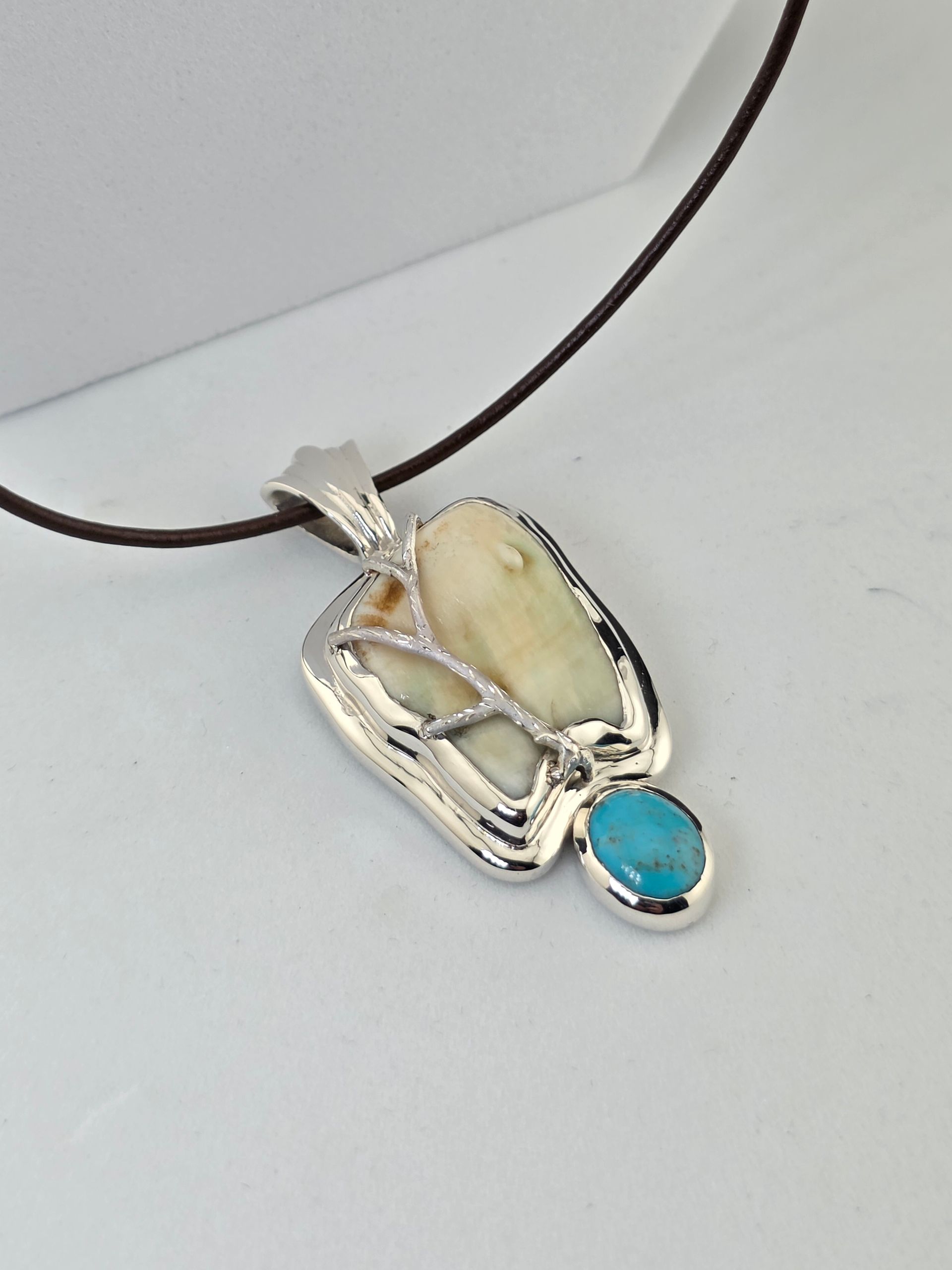 Silver pendant necklace with Elk Ivory and turquoise stones on a dark cord