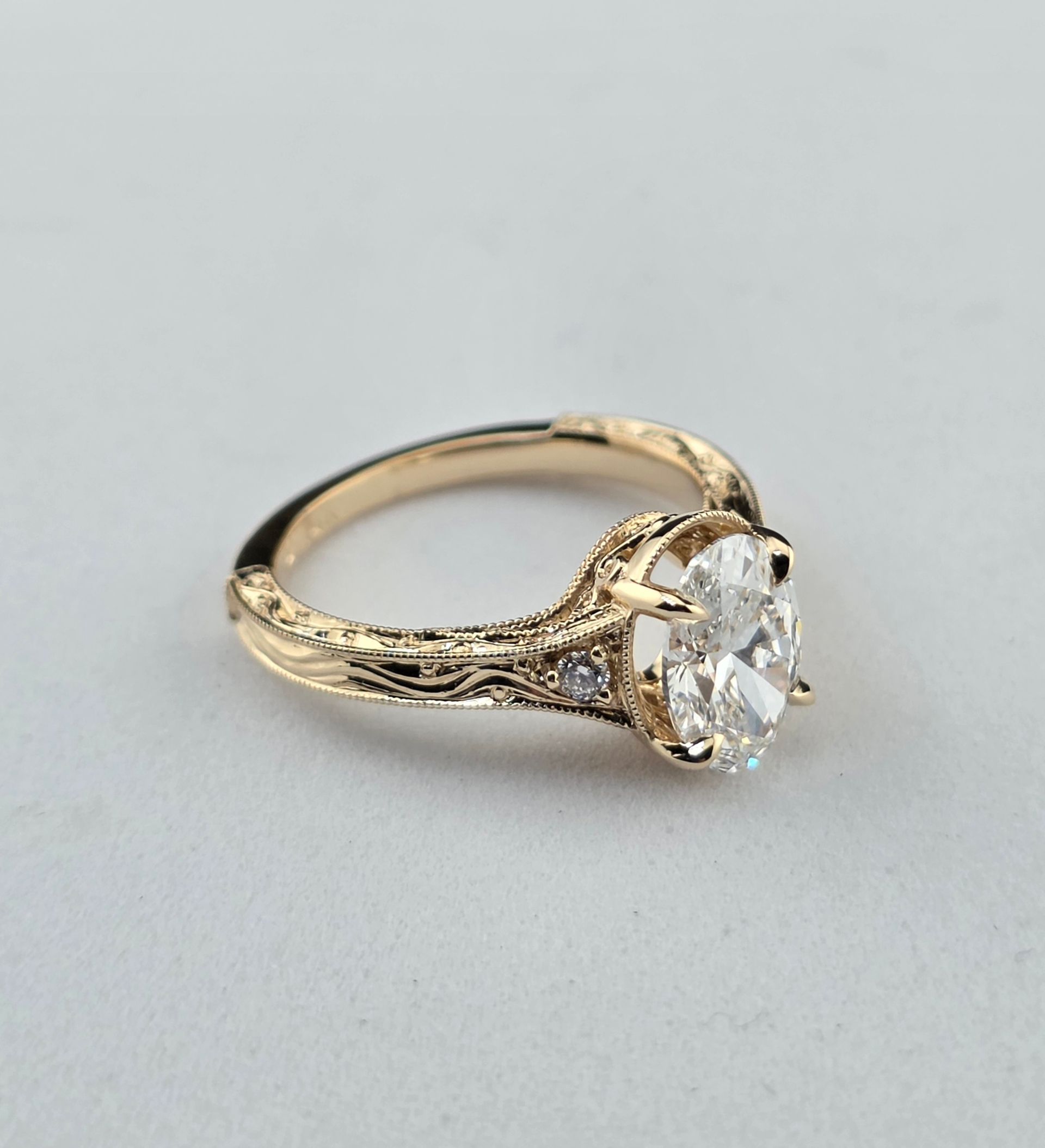 Vintage Gold ring with a large oval Diamond and textured band on a light gray background