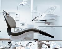 Modern dental clinic with a reclining chair, overhead lamp, and white cabinets