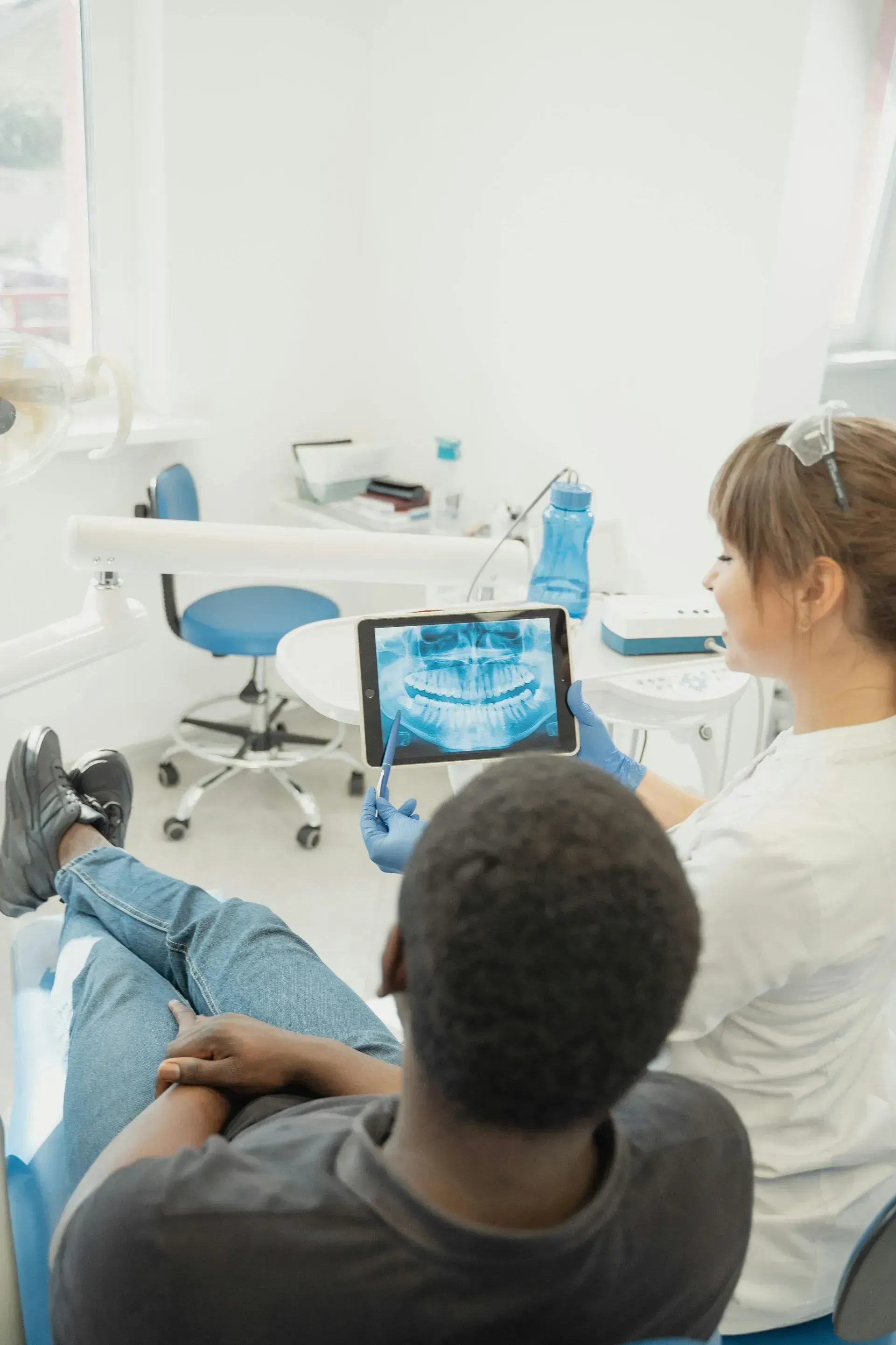 Dentist and patient watching an x-ray on a tablet in a bright dental clinic