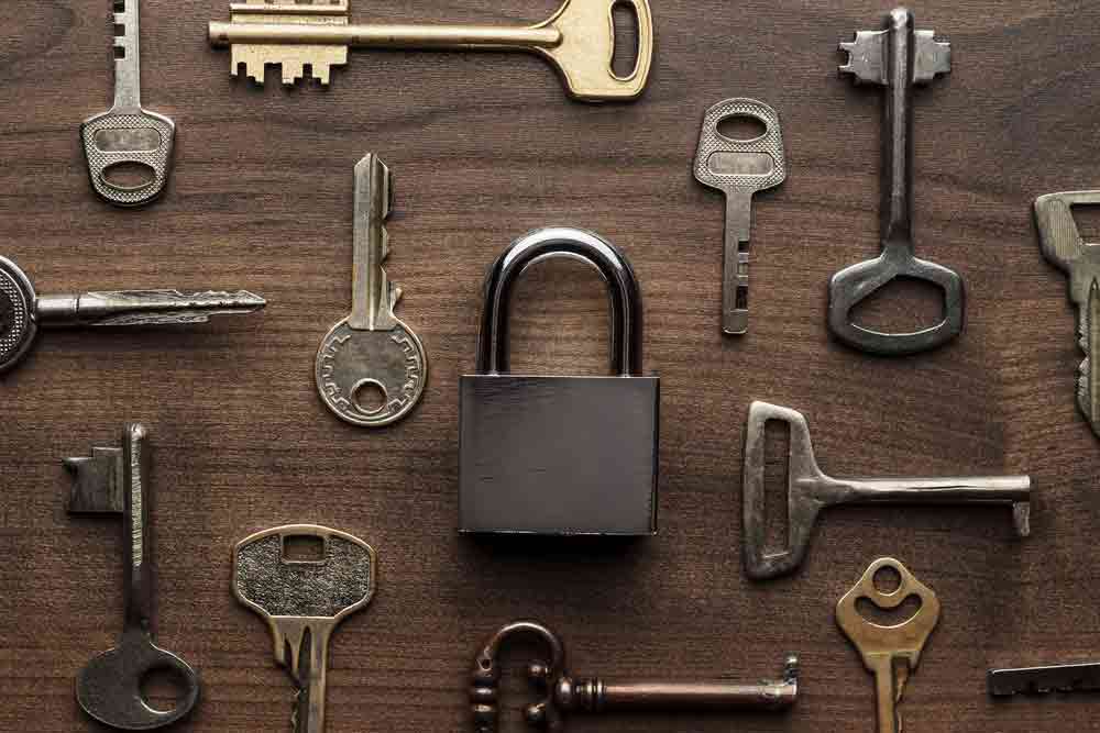Lock And Different Keys On Wooden Table — Coast 2 Coast Locksmiths in Buderim, QLD
