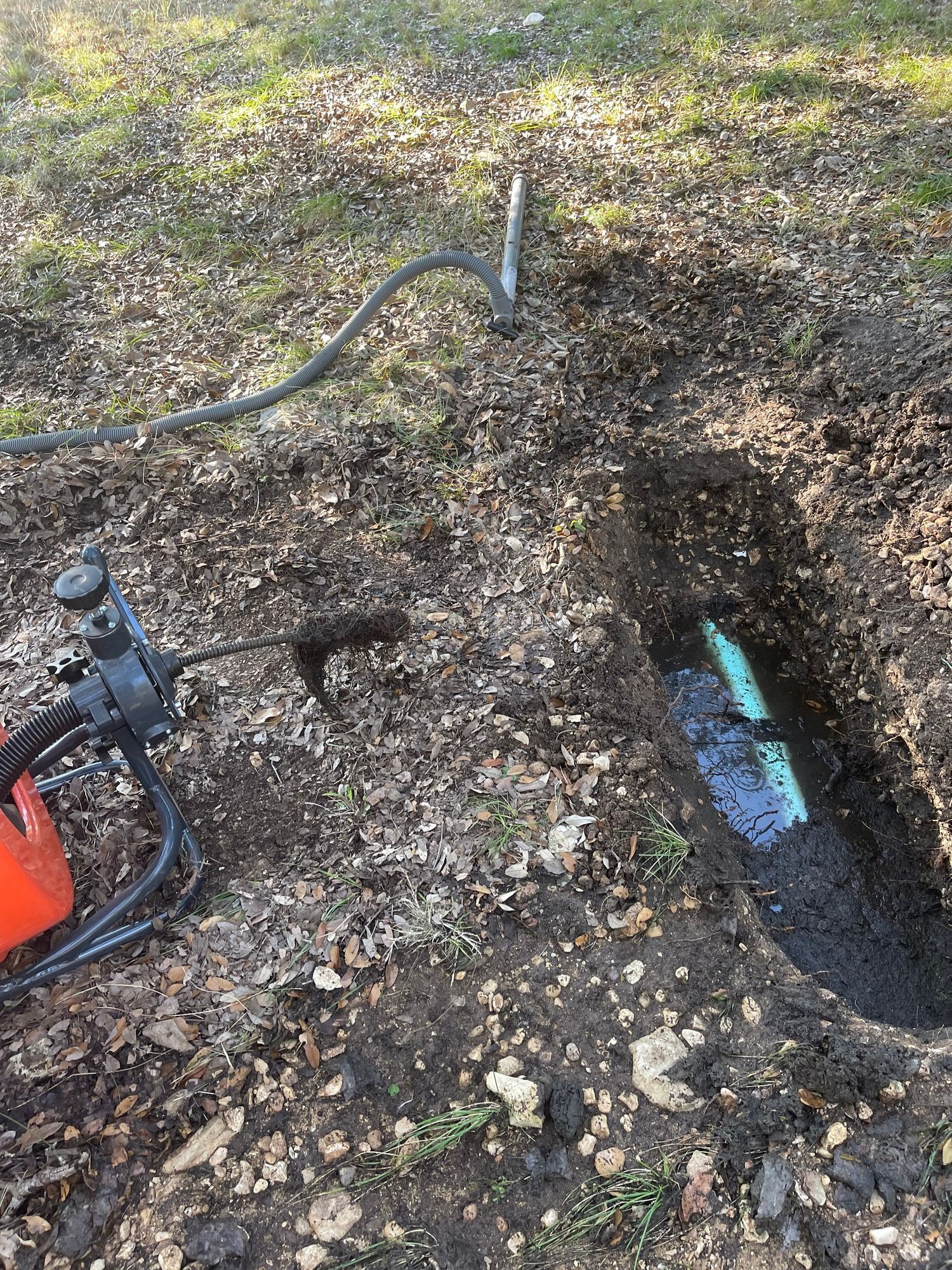 A hole in the ground with a pipe coming out of it.