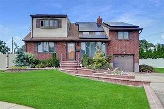 Suburban brick house with a front lawn, driveway, and attached garage