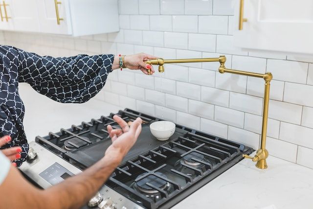 Pair of hands inspecting a black stovetop