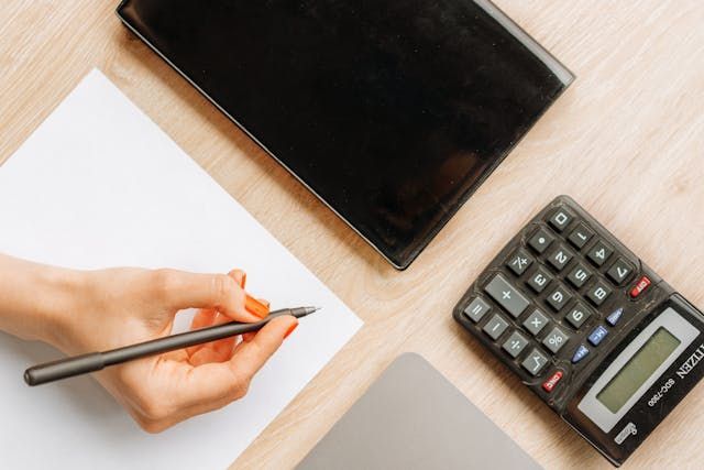 A person Holding a Pen with a Calculator