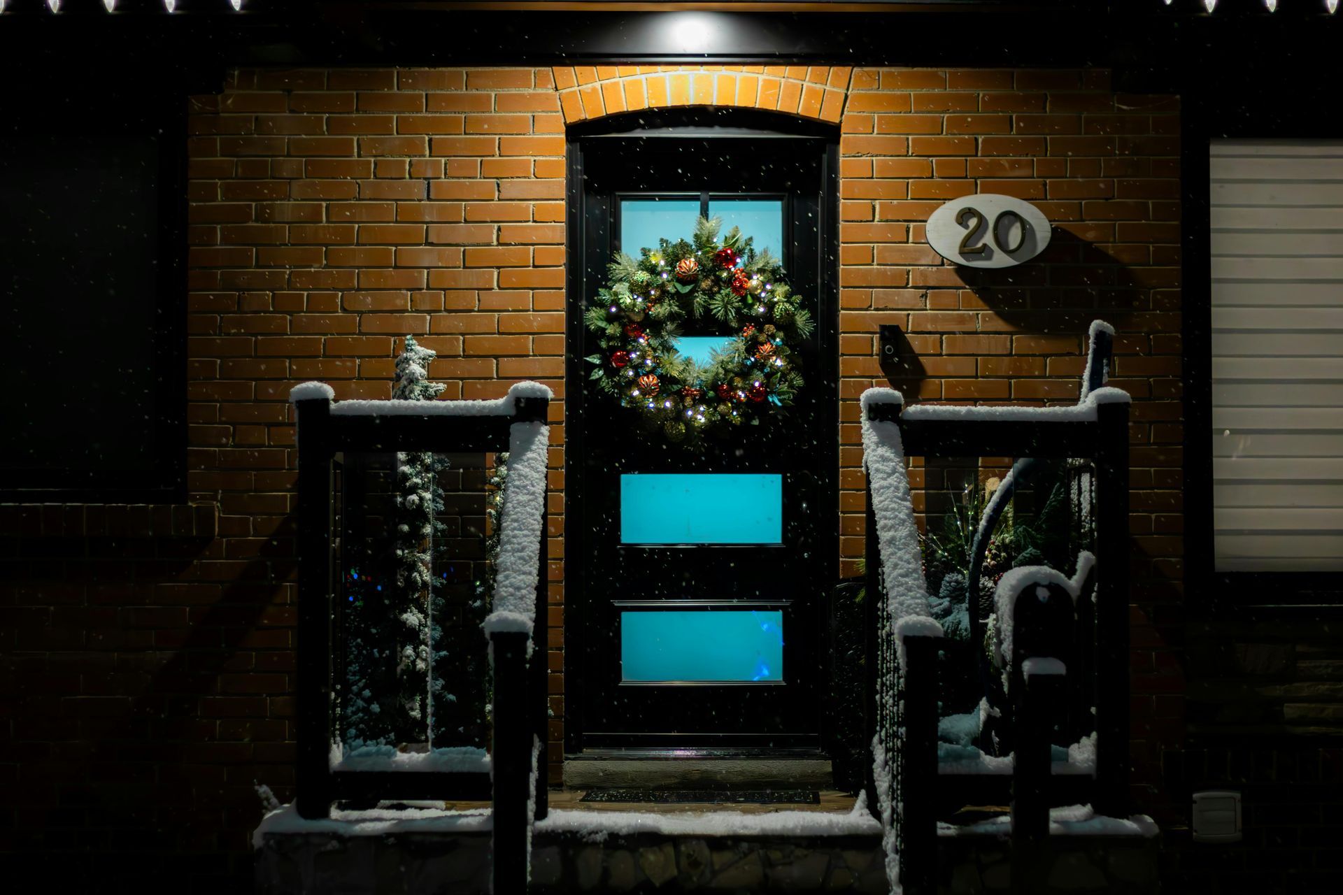 Front door with wreath and snow-covered steps