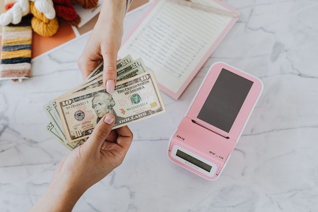 Two hands exchanging U.S. dollars