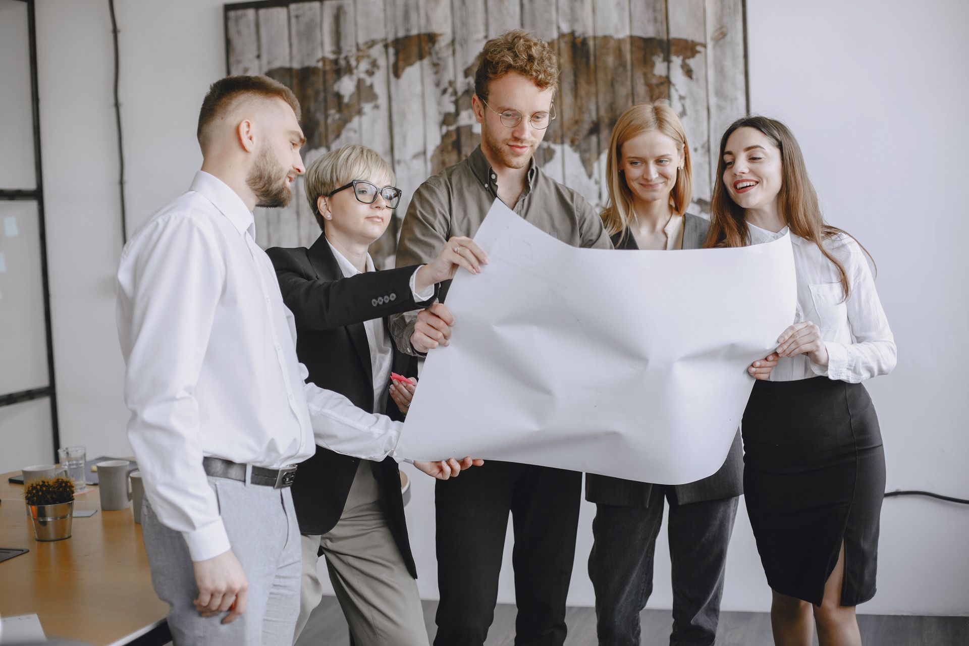 Group of professionals in an office setting analyzing project plans together.