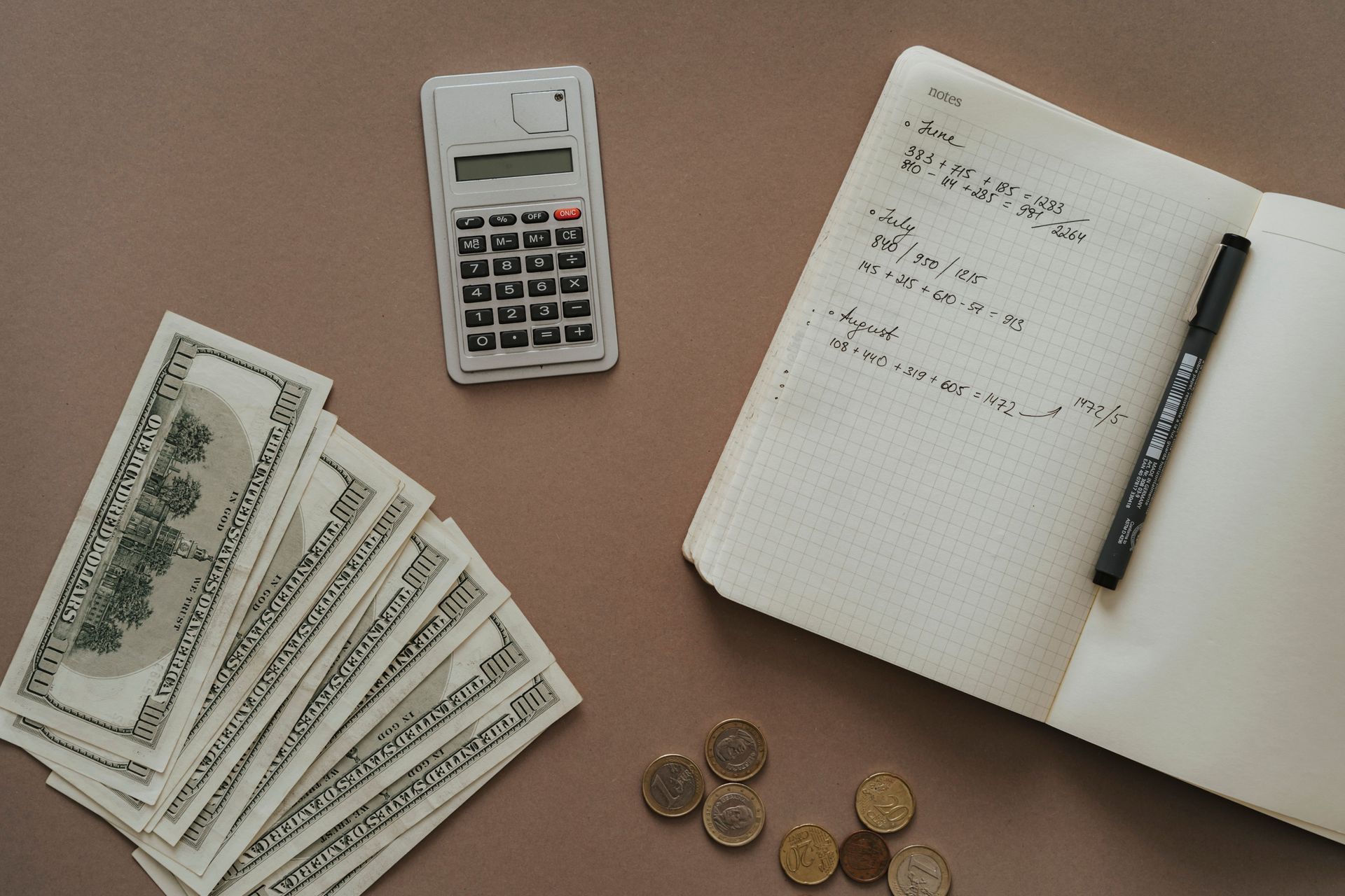 calculator, notebook, and US dollars