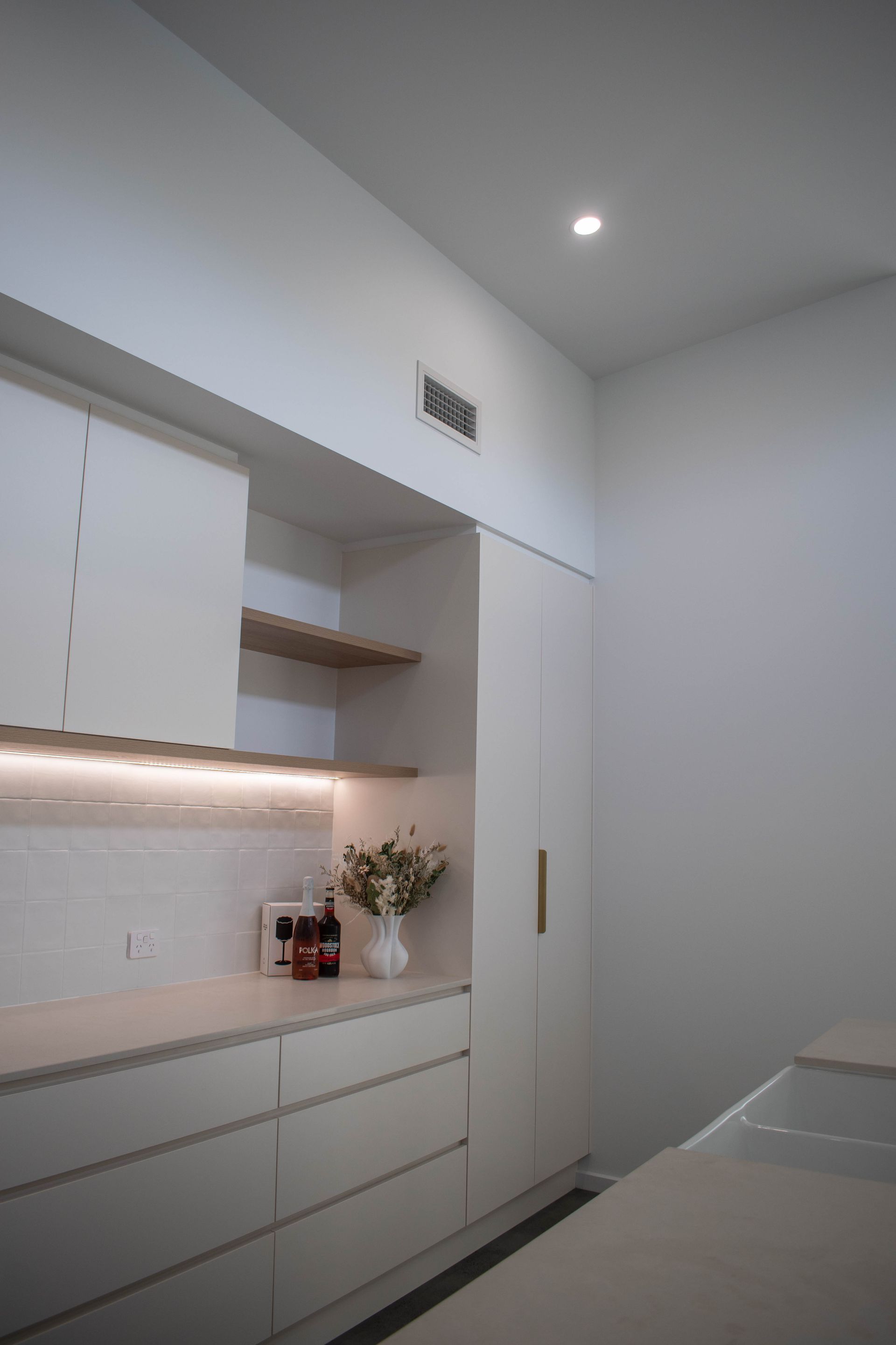 A Person is Installing a Light Switch in a Wall — Anderson Electrical & Air in Taree, NSW
