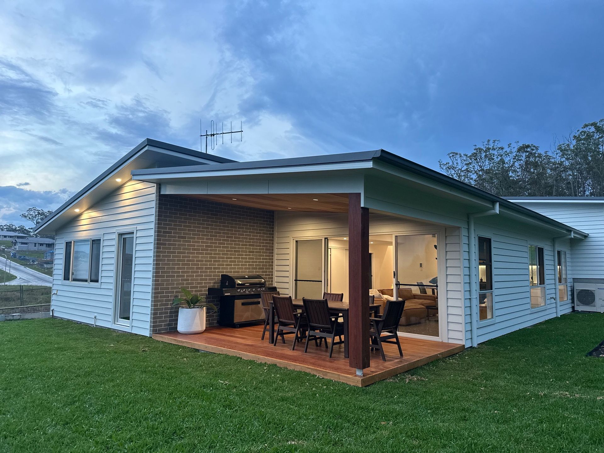 A living room with a brick wall and a flat screen tv — Anderson Electrical & Air in Mid North Coast, NSW