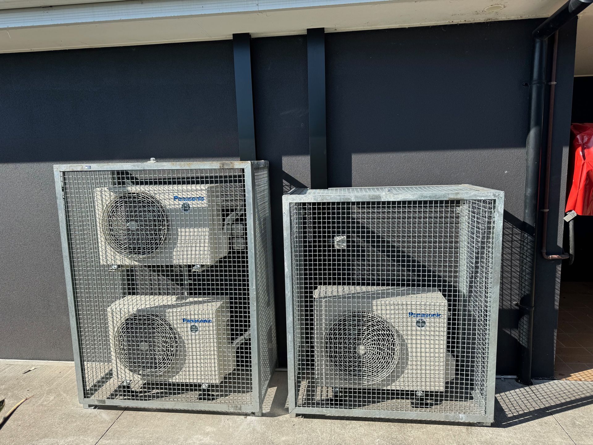 A Man is Looking at a Vent on the Wall — Anderson Electrical & Air in Taree, NSW