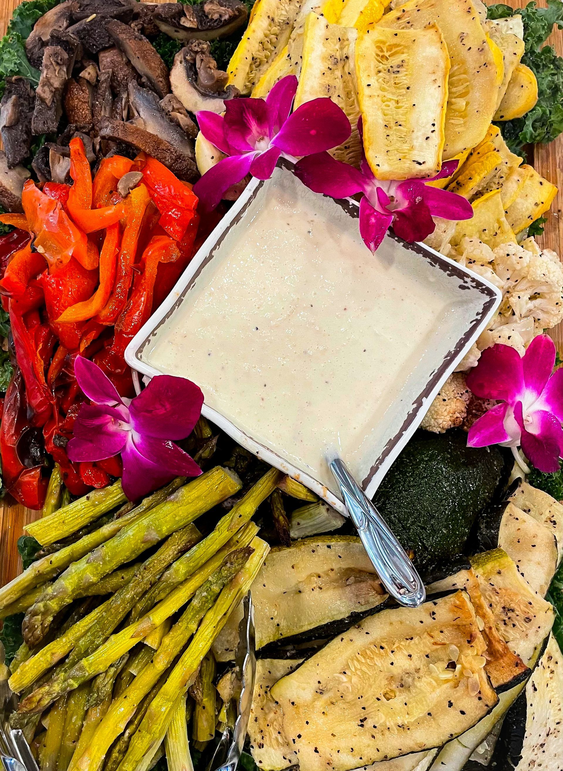 A tray of vegetables with a dipping sauce on top of it.