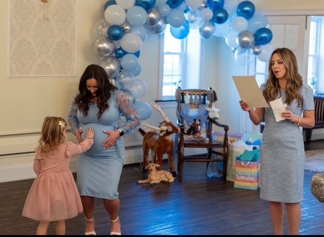 Two women standing next to each other in a room with balloons