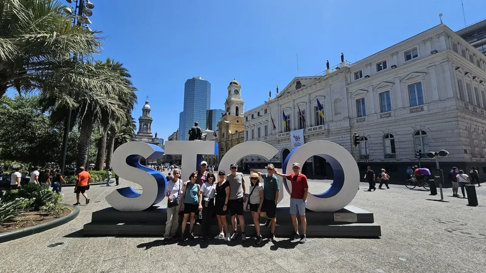 Private walking tour group in Santiago posing by the STGO letters at Plaza de Armas